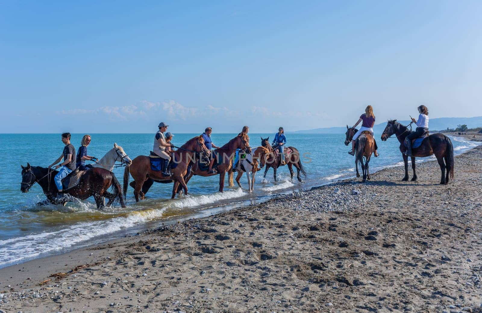 Policoro, Italy - 7 May 2023: People riding horses in a Policoro beach, Basilicata, southern Italy.