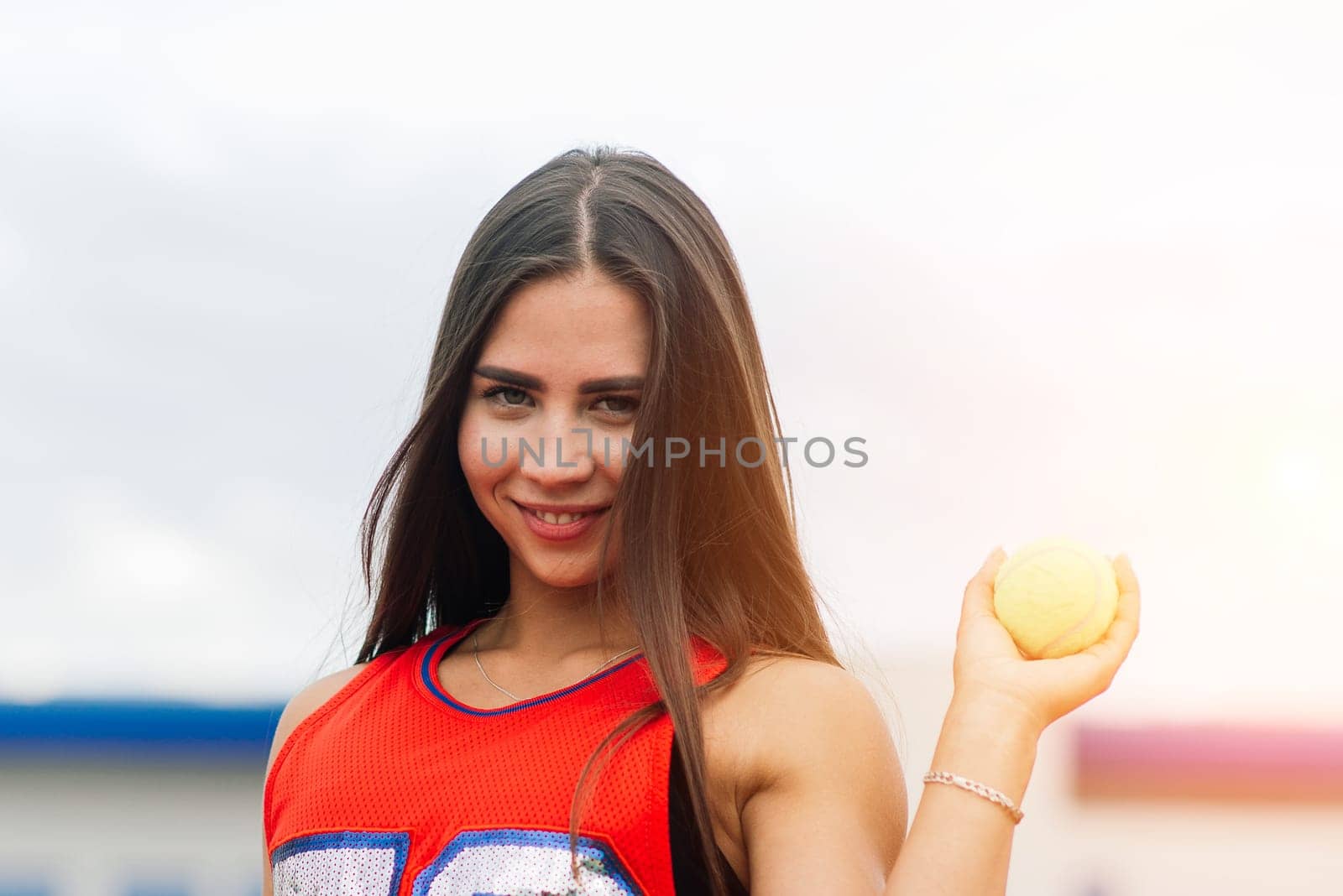 Portrait of tennis player girl holding ball outside with protective masks