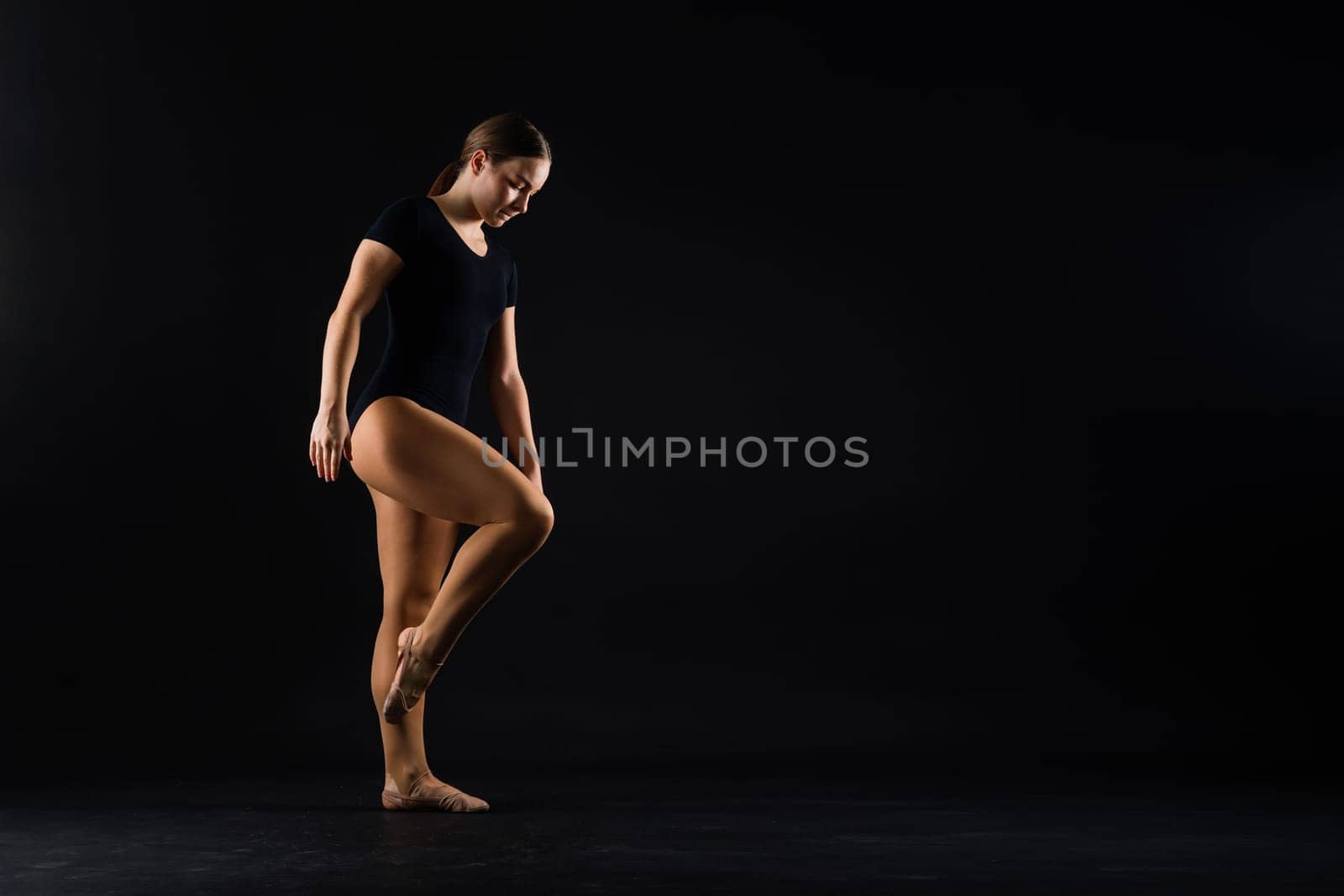Portrait of a beautiful young woman gymnast training calilisthenics exercise with acrobatic element