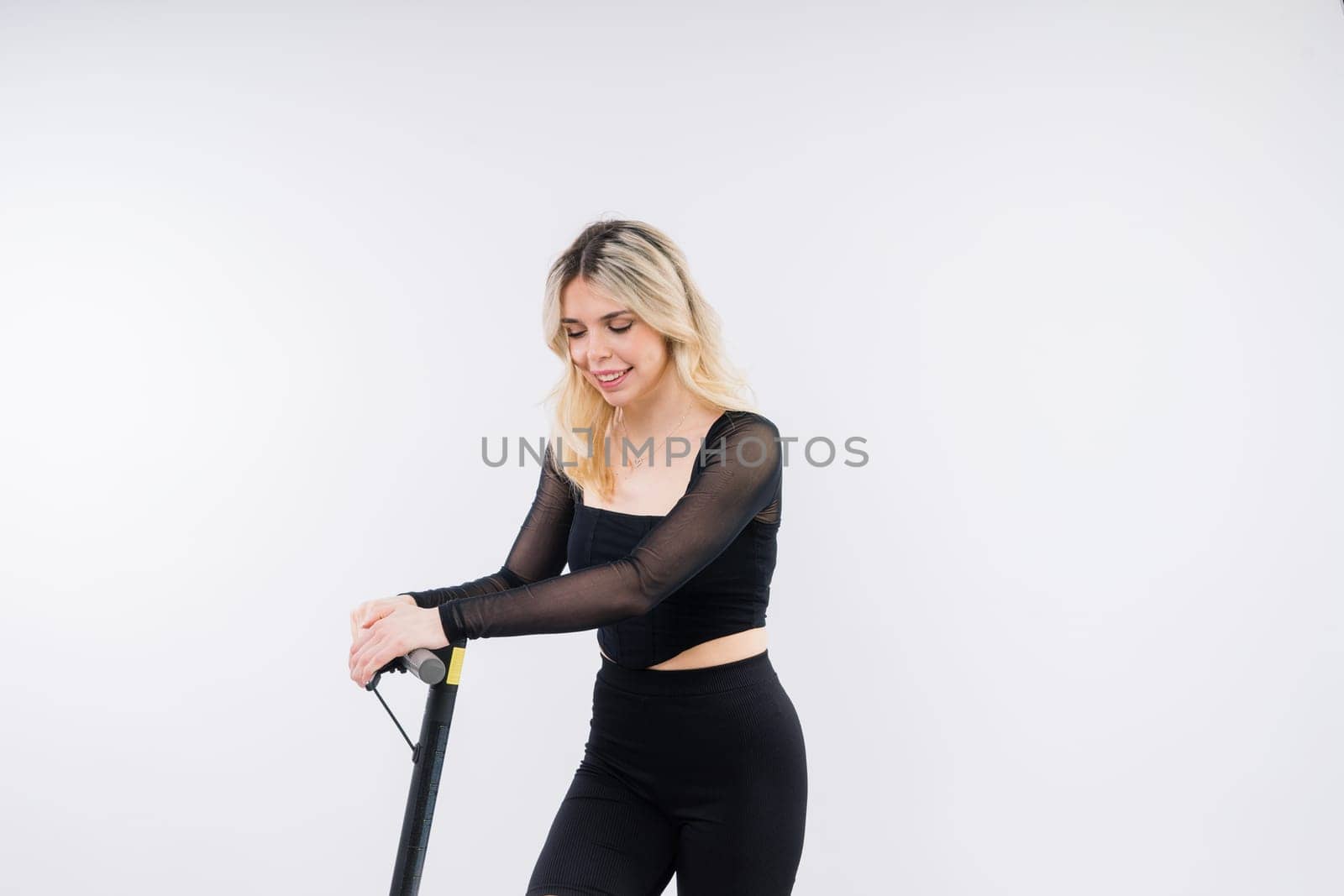 Blonde woman on a red and white background sit and stand with electro scooter and resting