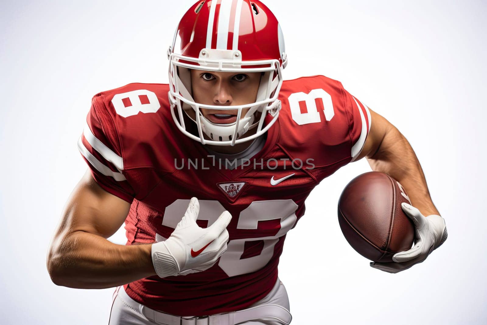 Portrait of American football player in red jersey holding ball against white background.