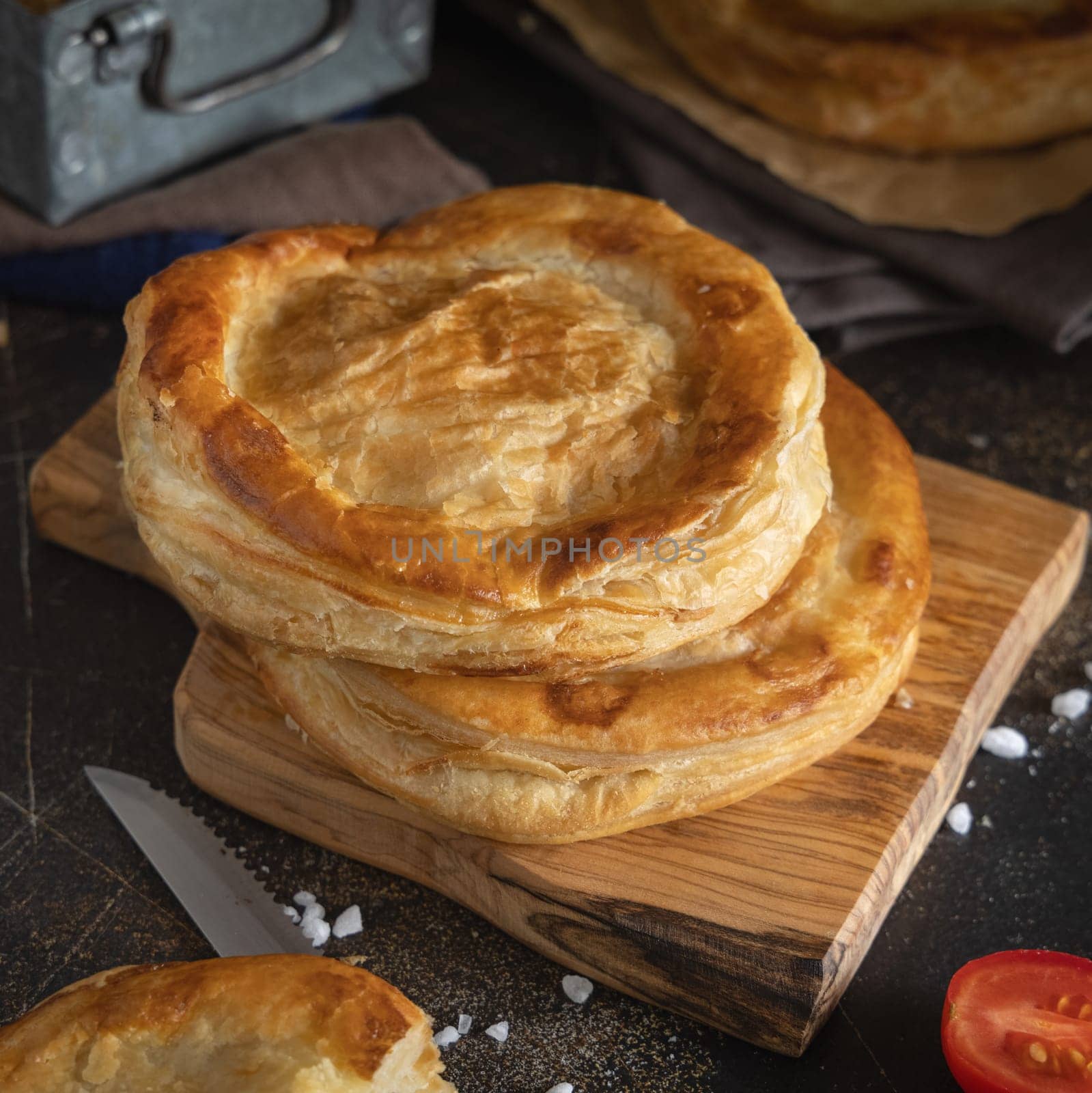 Rustico traditional puff pastry stuffed with bechamel sauce, tomato and mozzarella cheese, close up on a dark table. Traditional street food from Salento, Lecce, Italy