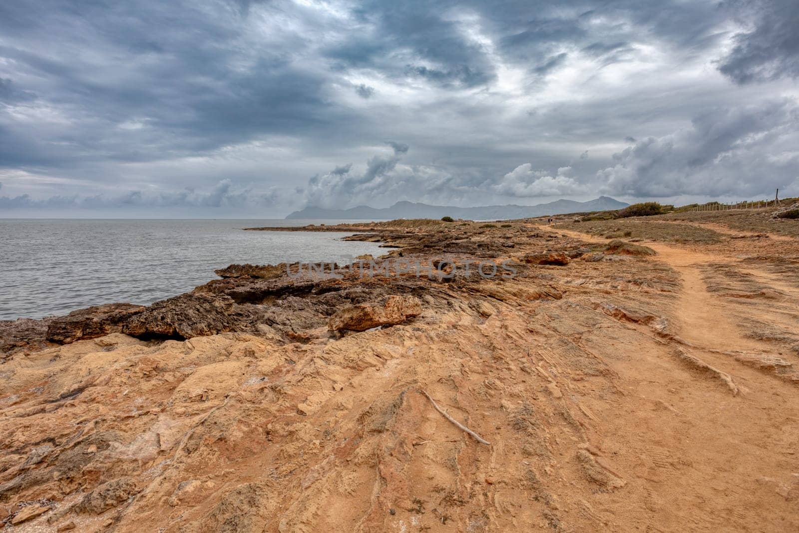 Natural beach near city Can Picafort with small Lighthouse in background. Balearic Islands Mallorca Spain. Travel agency vacation concept.