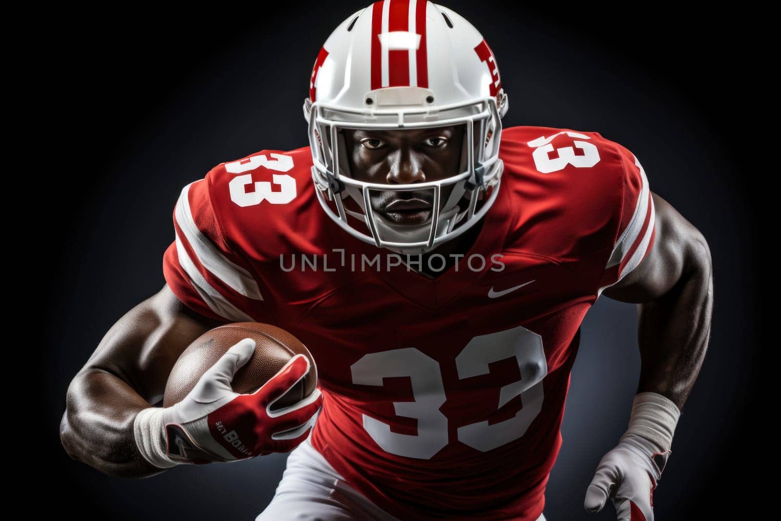 American football player in red jersey and helmet holding ball against black