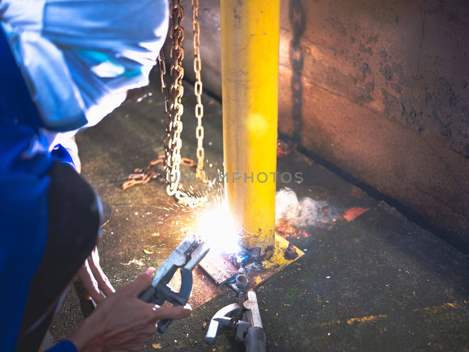 Industry worker welding steel structure at work background.