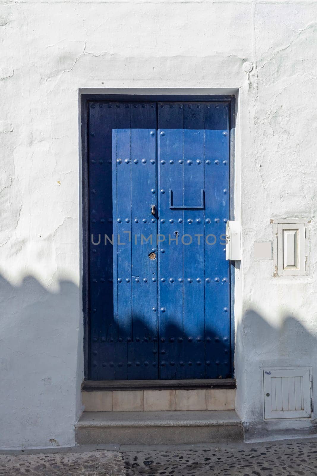Vintage window and blue door on old traditional house in Andalusia, Spain
