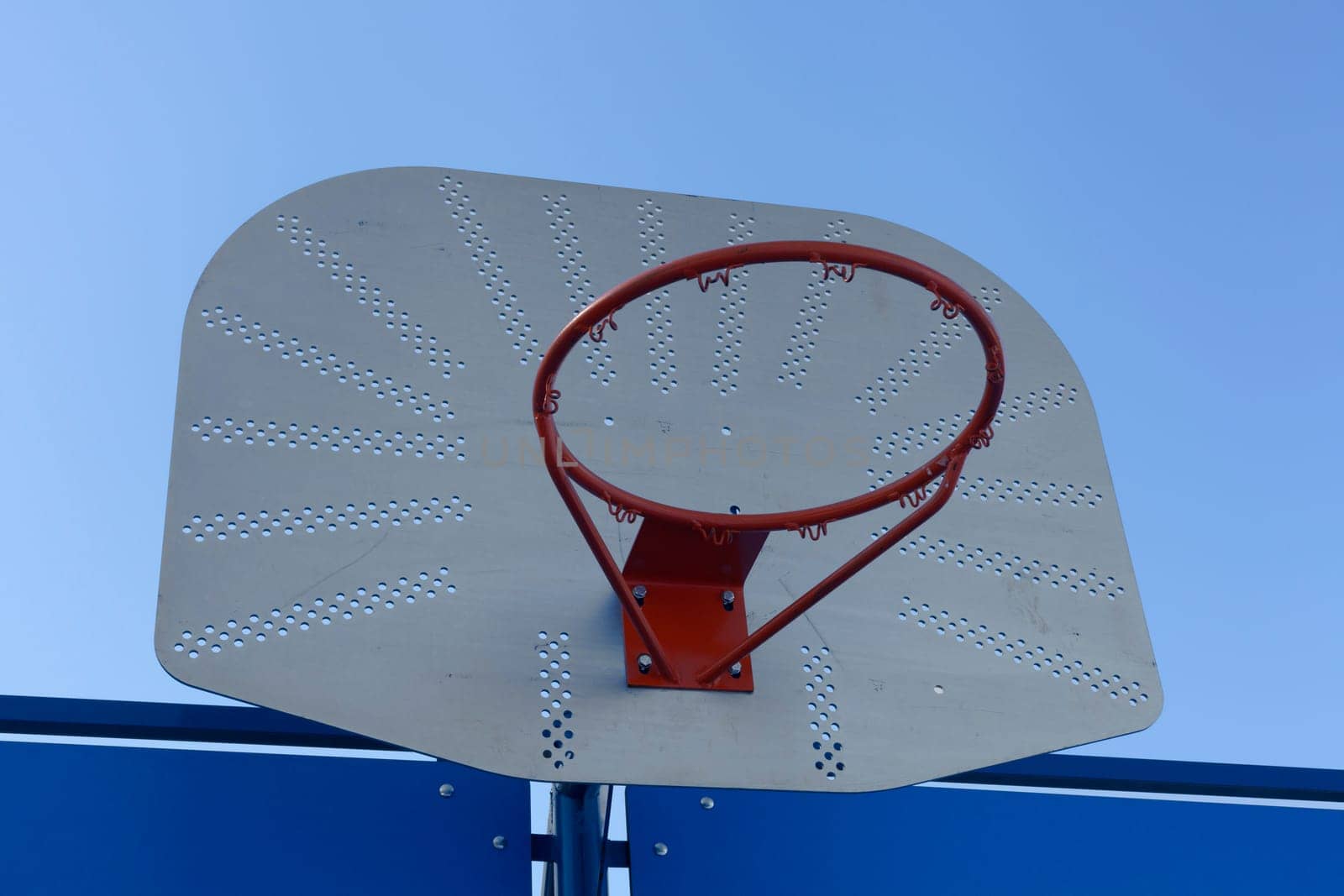 Outdoor basketball hoop against a blue sky - street basketball