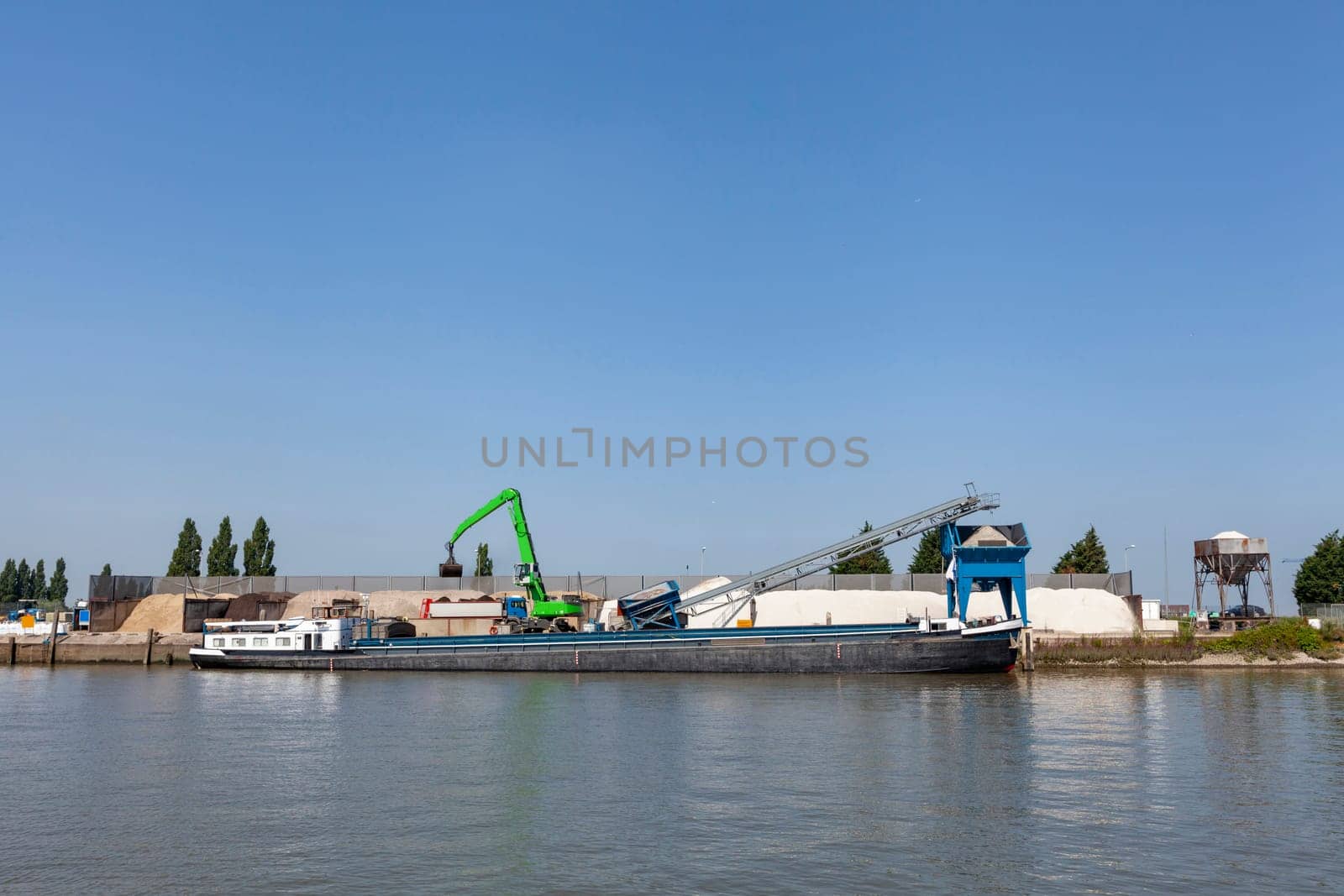 Loading barge with sand and rubble on a small berth. Freight transport logistics