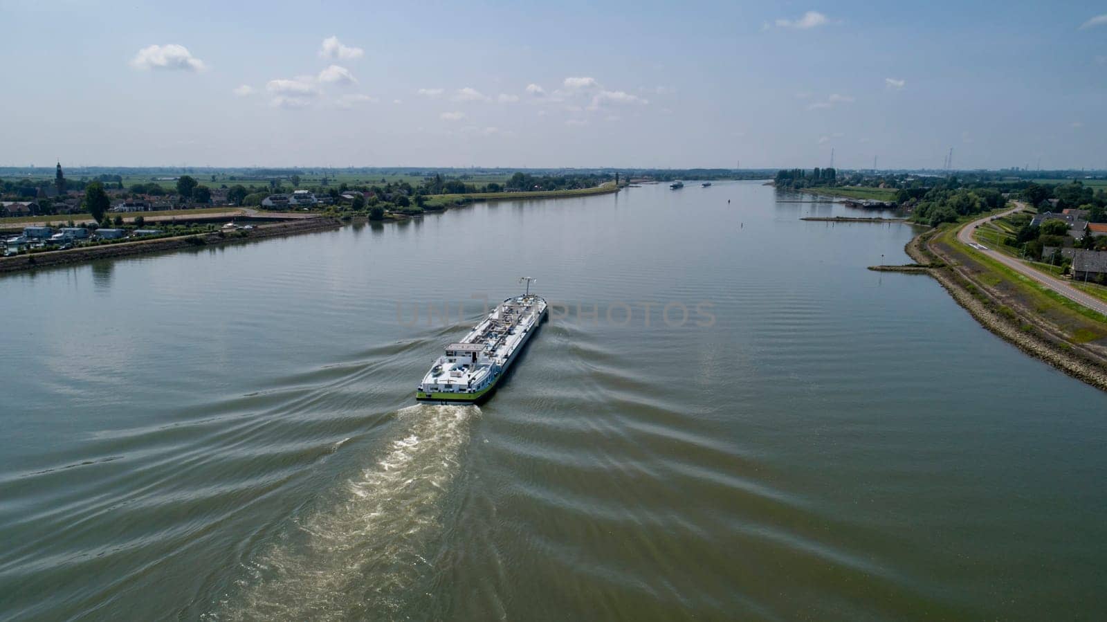 Aerial view:Barge with cargo on the river. River, cargo barge, highway with cars.. Cargo ship on the river
