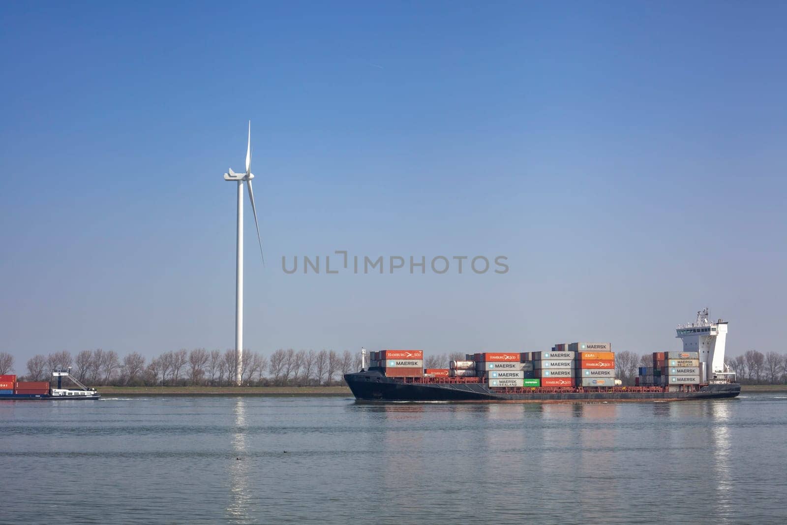 Netherlands, New Waterway. Container ship in front of modern windmill shipping, transport and heavy industry nera Maasvlakte 2.
