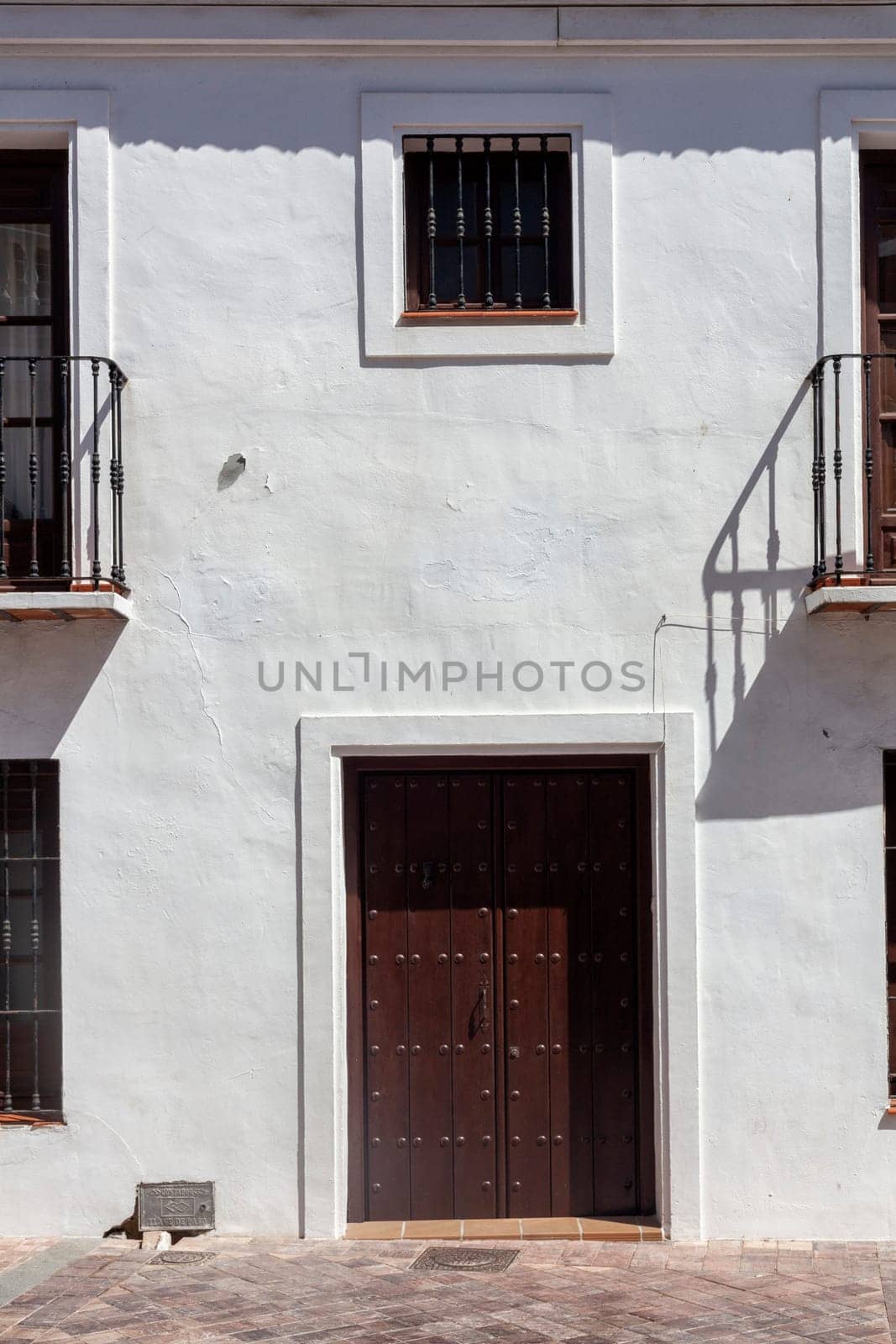 Closed Old vintage wood Door with door lock in white concrete wall, empty abstract interior, square background texture