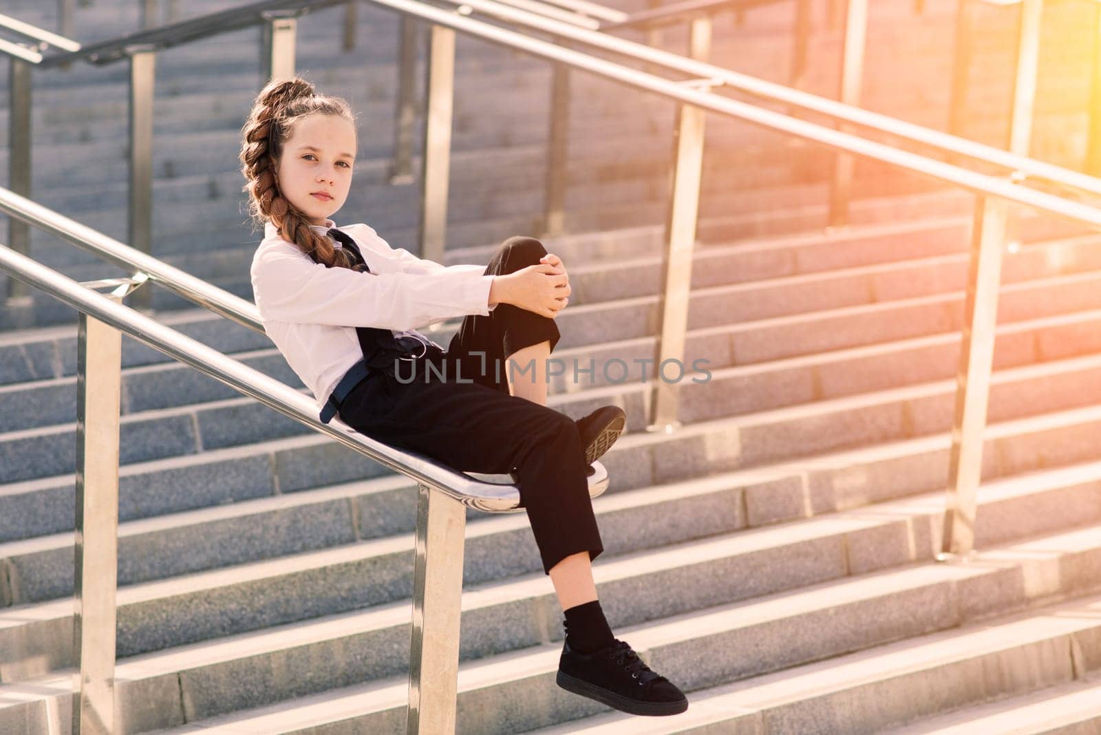 Teenage schoolgirl talking on phone, happy smiling, having fun, autumn city