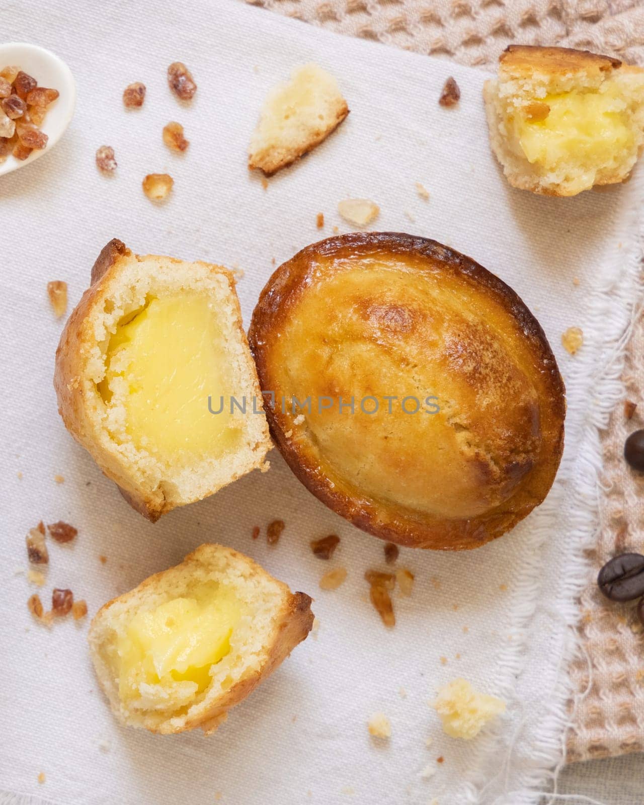 Pasticciotto leccese pastry filled with egg custard cream, typical sweet from Lecce, Italy. Pieces of pasticiotto on a beige napkin, typical sweet for apulian breakfast, top view