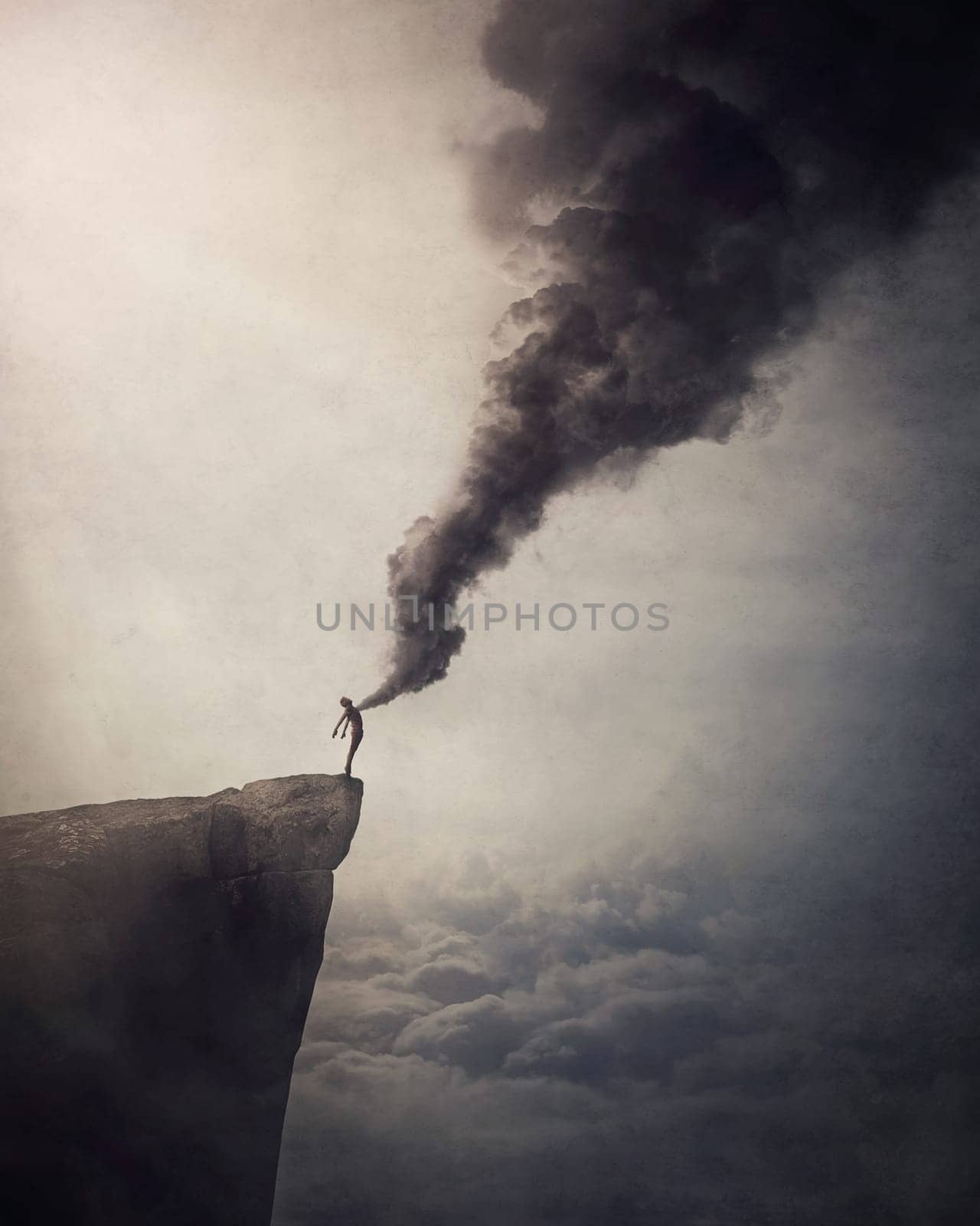 Deliver from evil conceptual scene with a person on the edge of a cliff liberates a dark smoke out of his chest as relieve his body and mind from fears, stress and negative emotions