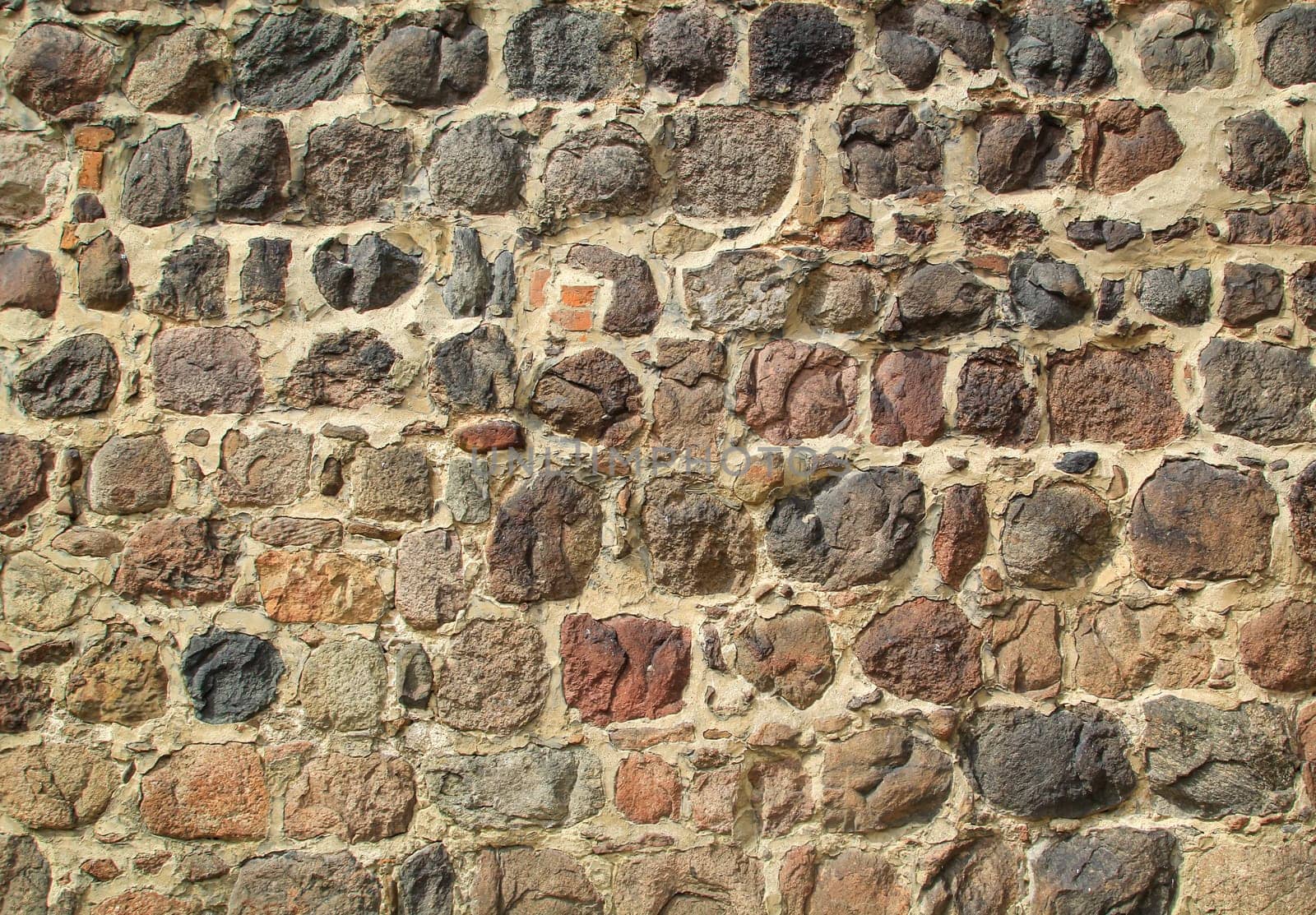 Texture of a wall built on many fieldstones.