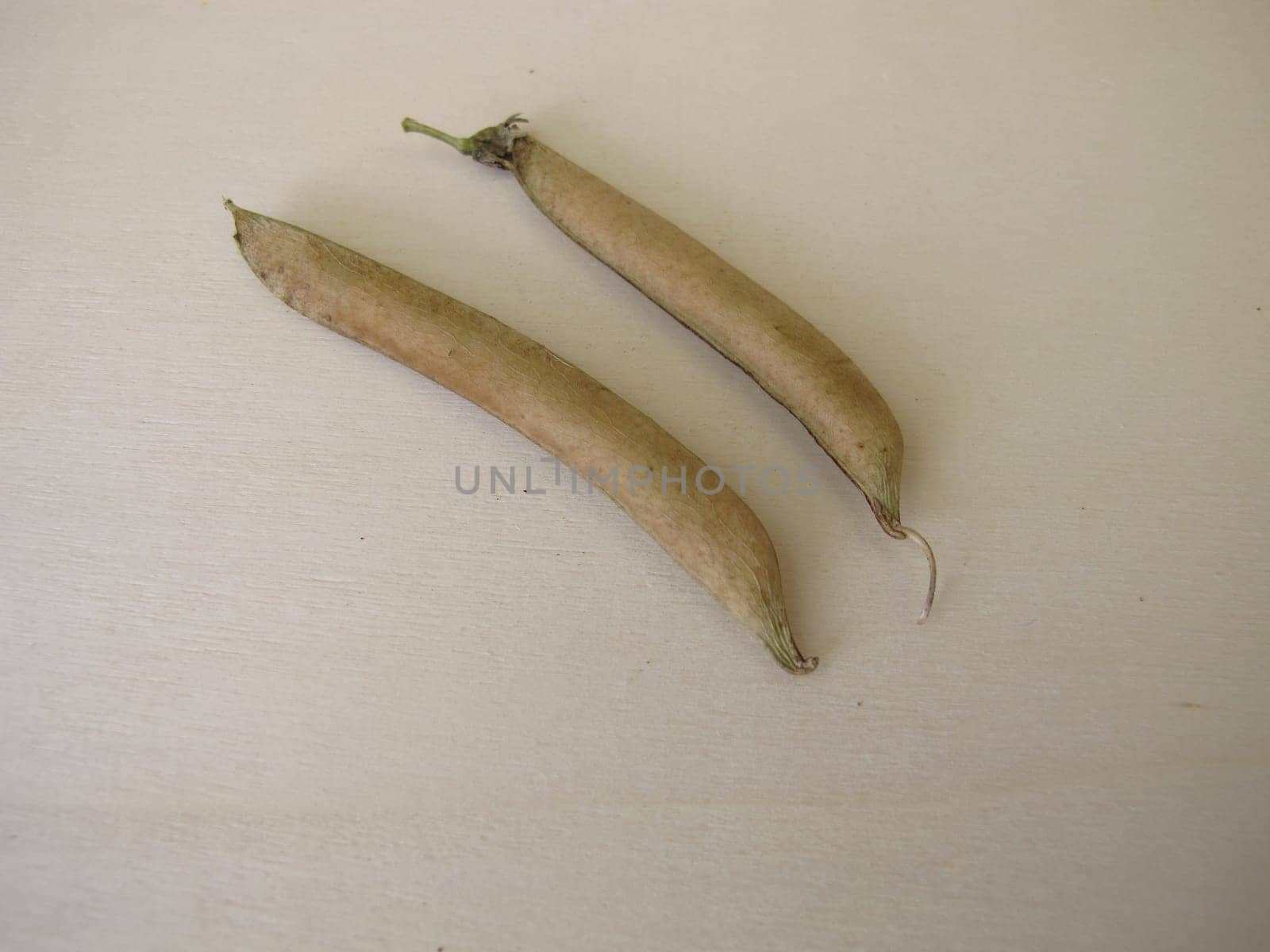 Ripe sweet pea pods on a wooden board