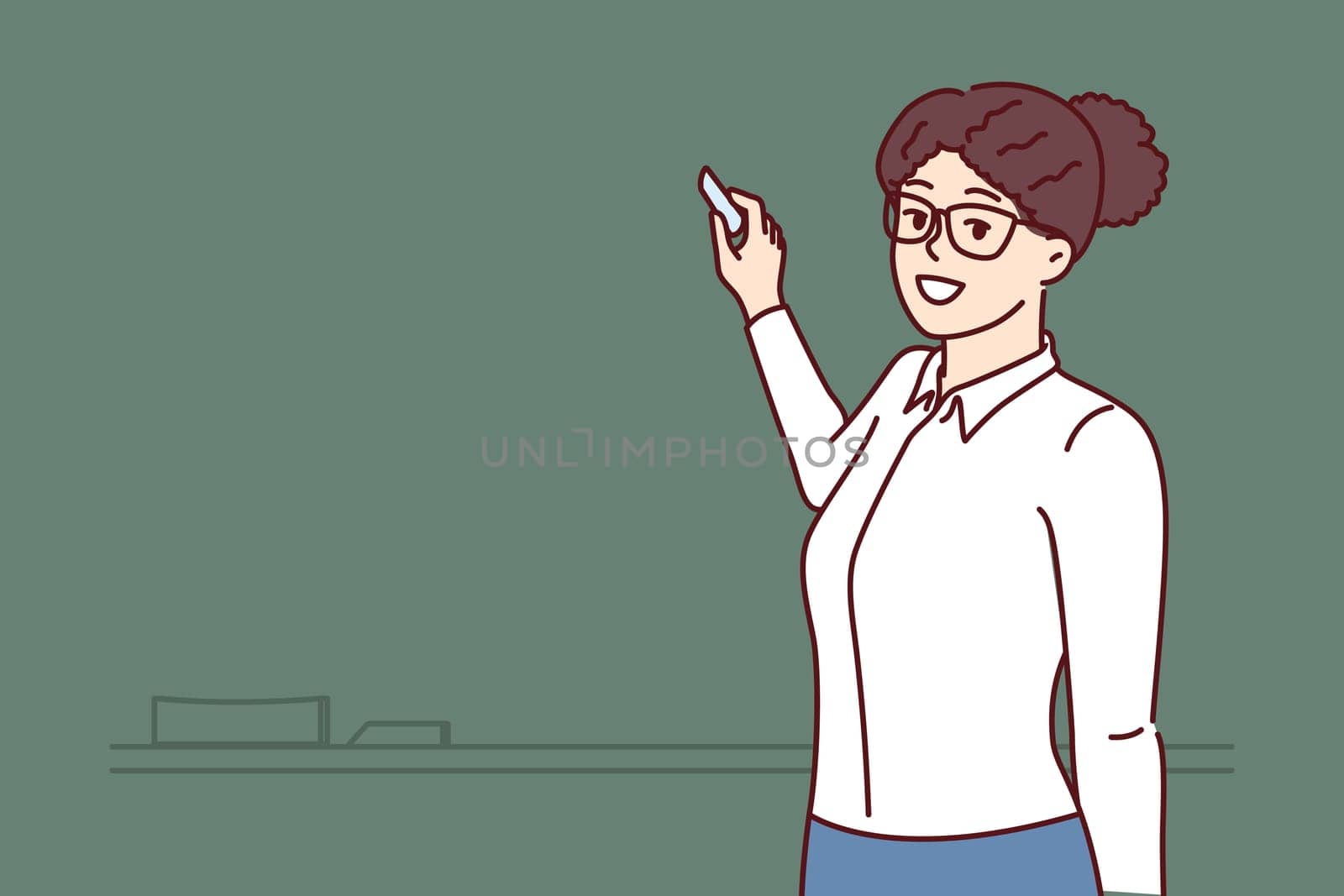 Woman teacher stands at blackboard and uses chalk, teaching elementary or high school children and giving students new knowledge. Happy teacher posing near empty chalkboard before class starts
