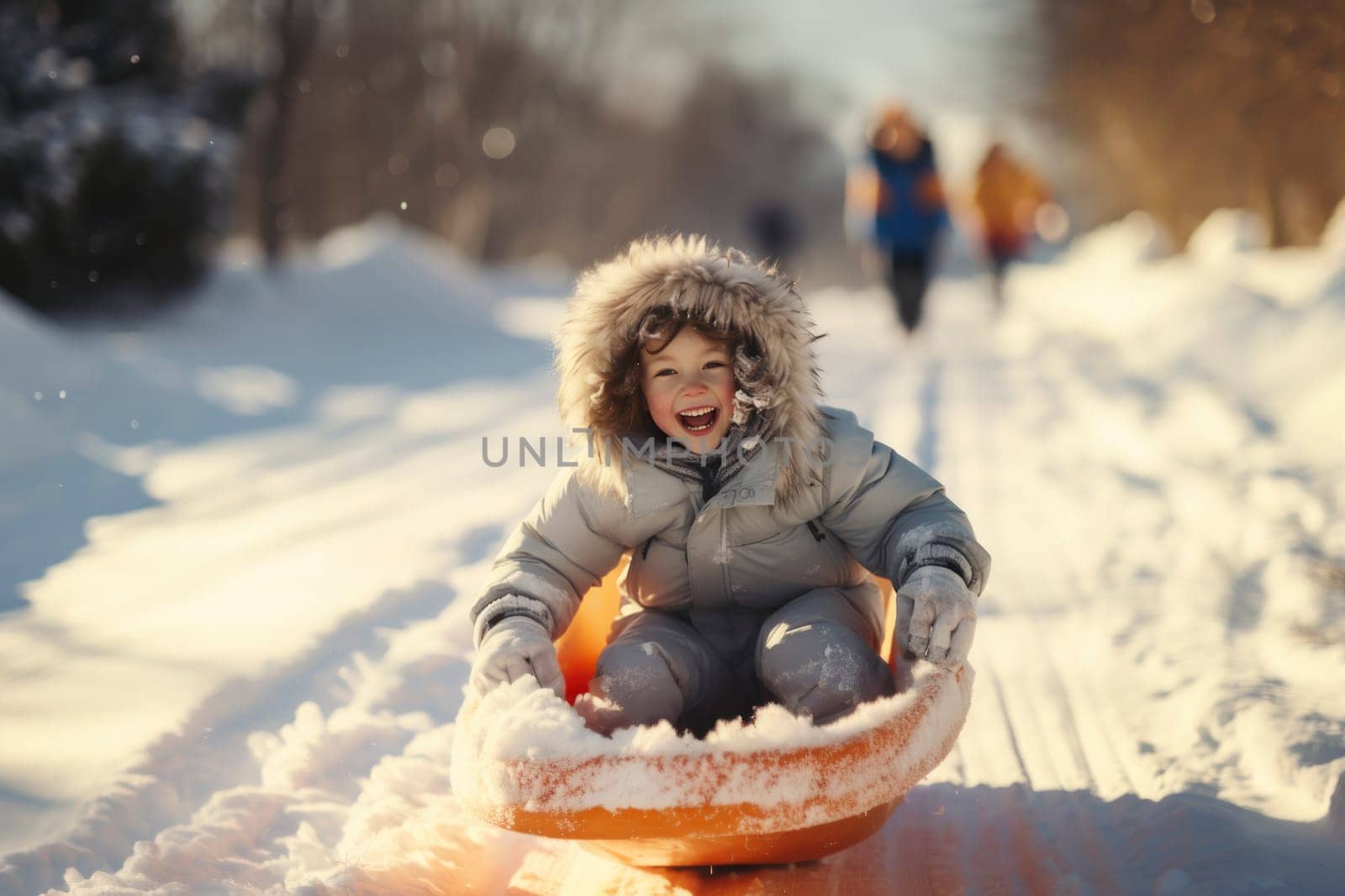 Concept of childhood, sledding in winter. Happy little girl is rolling down the hill on a sled.