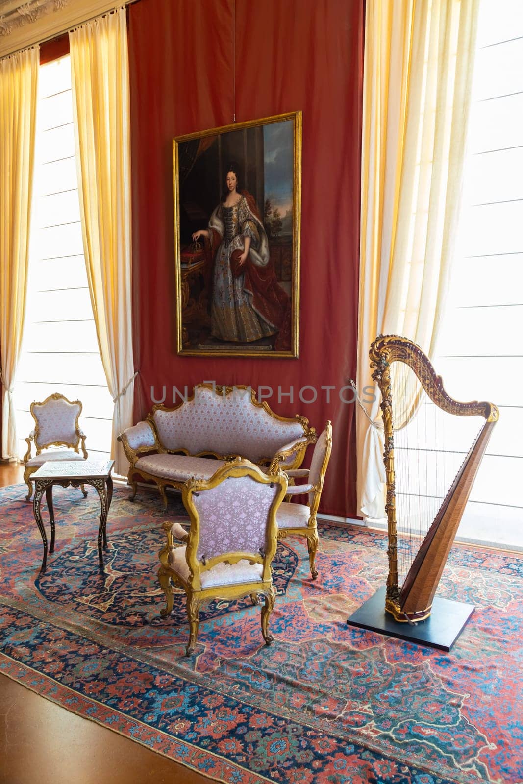 Venaria Reale, Italy - February 2023: luxury interior, old Royal Palace. Perspective with harp, window and baroque decoration.