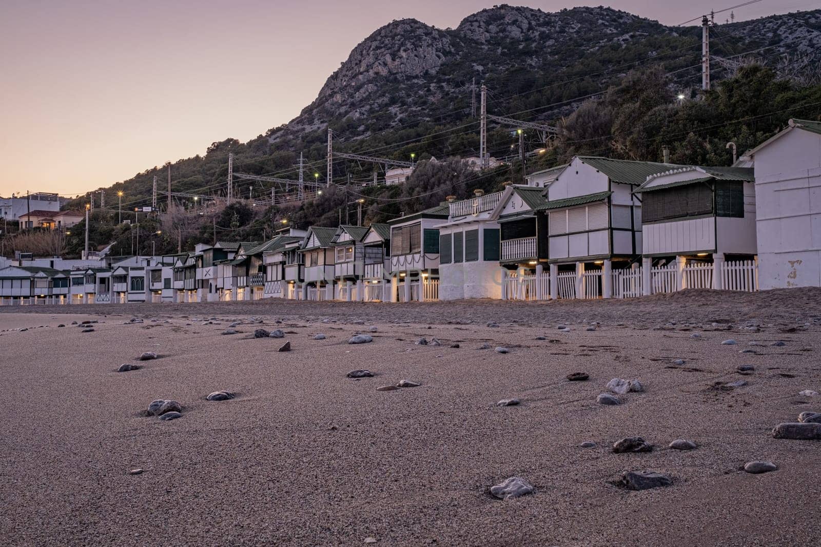 'Les Casetes del Garraf' (The Little Houses of the Garraf), typical white and green houses overlooking the Garraf beach, Catalonia, Spain.  An example of popular architecture characteristic of the Garraf and Mediterranean culture. Seascape at sunset.