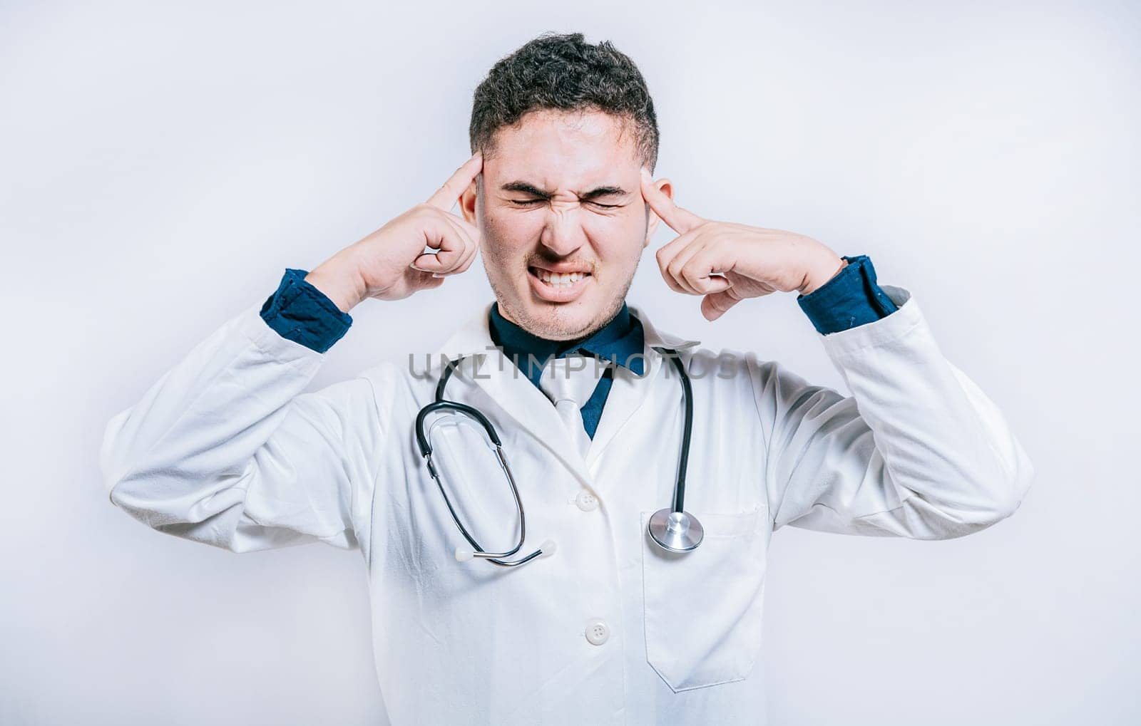 Doctor with migraine holding his head. Fatigued doctor with headache isolated, Young Doctor with headache isolated