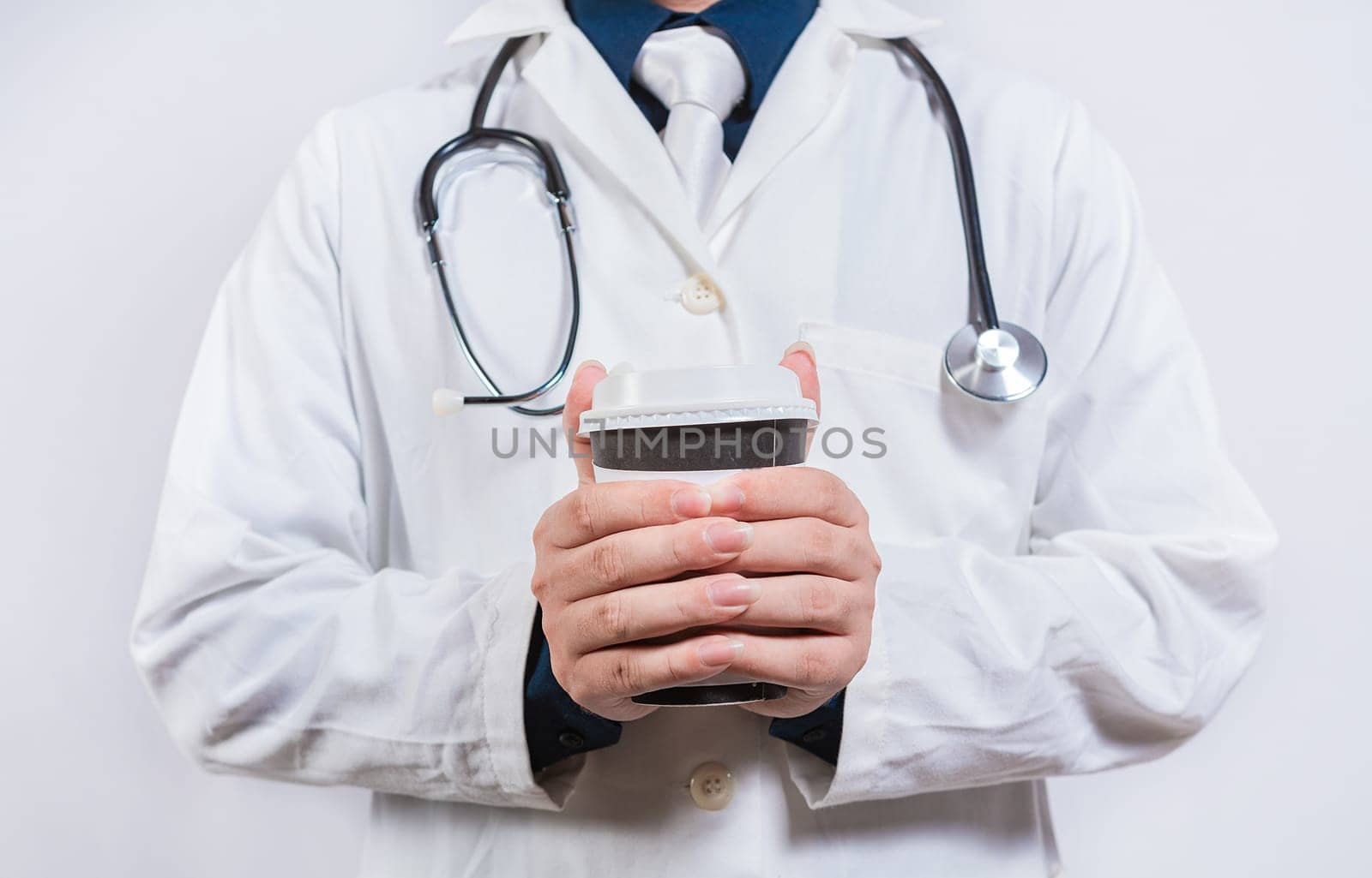 Hands of doctor holding takeaway coffee on isolated background. Doctor hands holding paper coffee