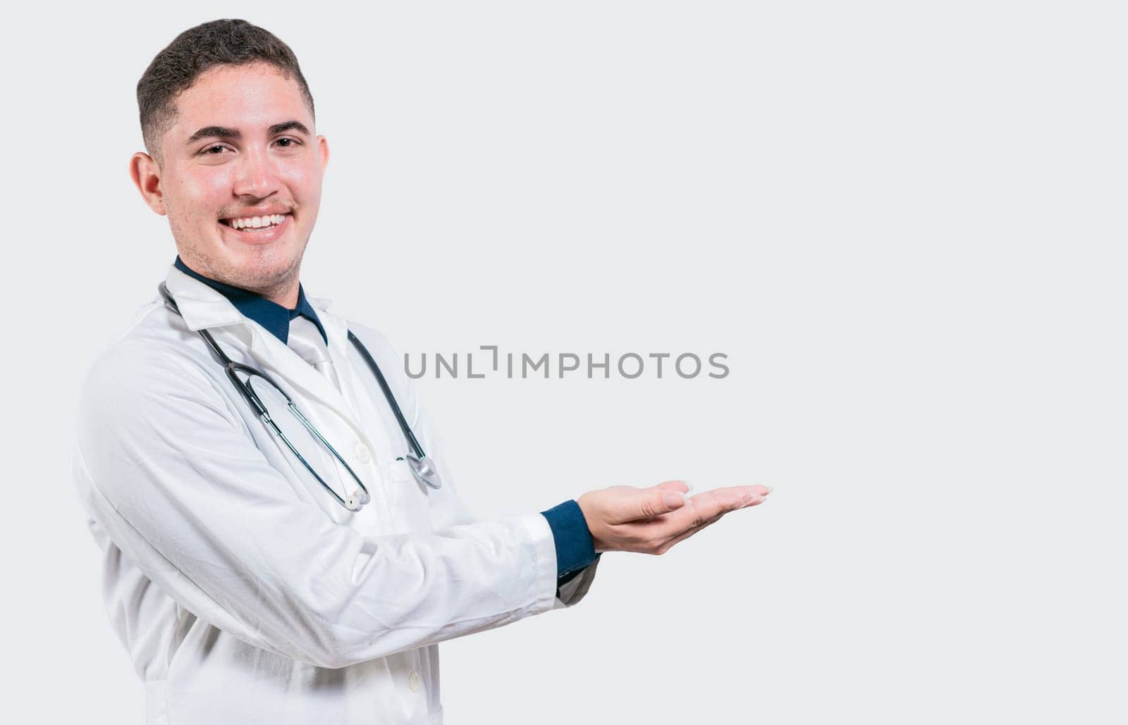 Happy doctor presenting something with his palms. Handsome doctor showing an advertisement with his palms