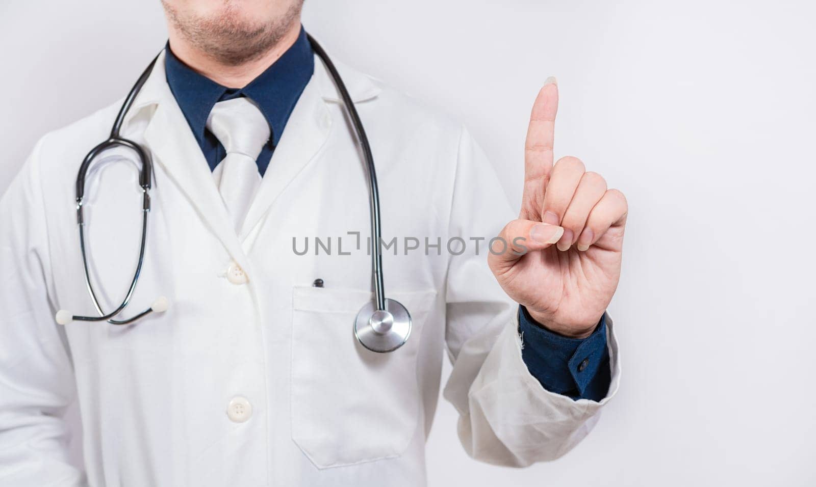 Unrecognizable doctor pointing up. Hand of doctor pointing up. Doctor finger pointing up with text space