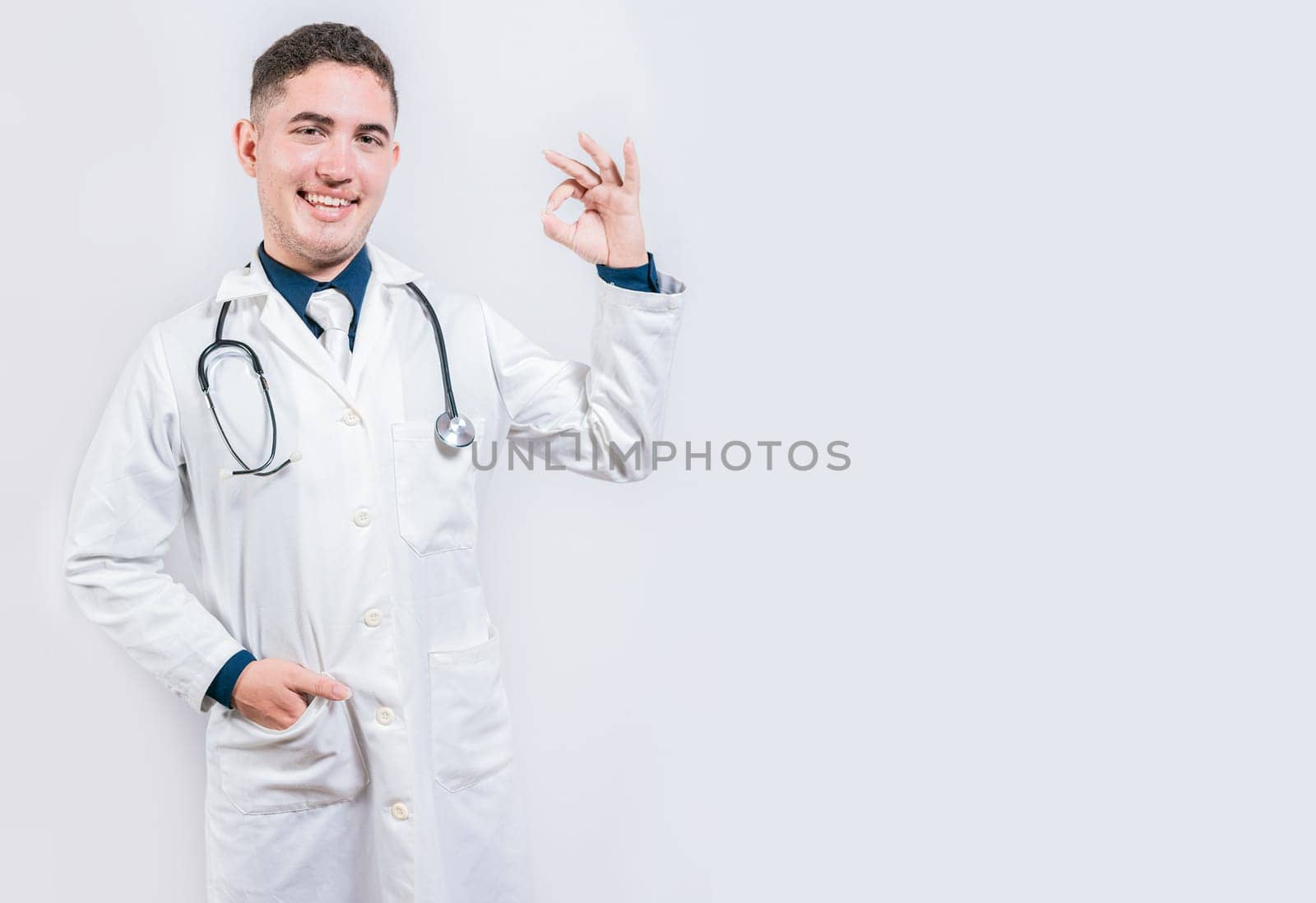 Happy doctor gesturing approval isolated. Friendly doctor approving and recommending isolated. Latin doctor approving on isolated background