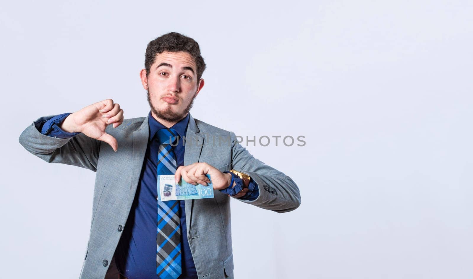 Business man holding banknote with thumb disapproving, man with money in hand and thumb down