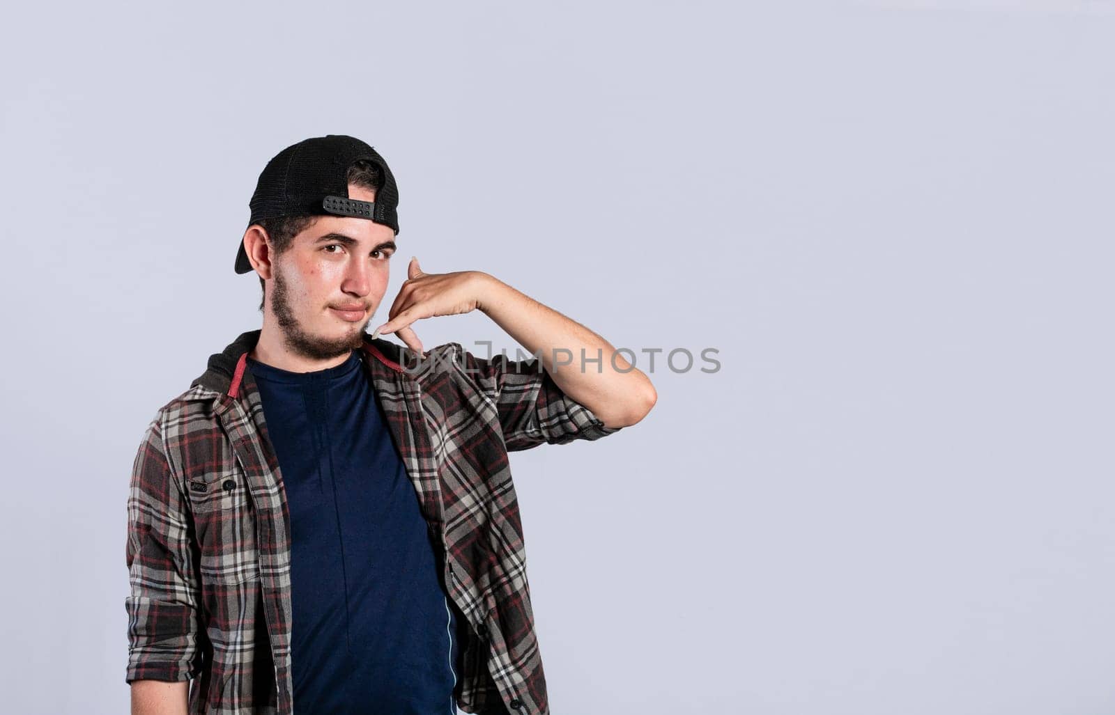 Man making phone gesture with his fingers, Hispanic young man making phone gesture and pointing to the front, a signal of a man calling