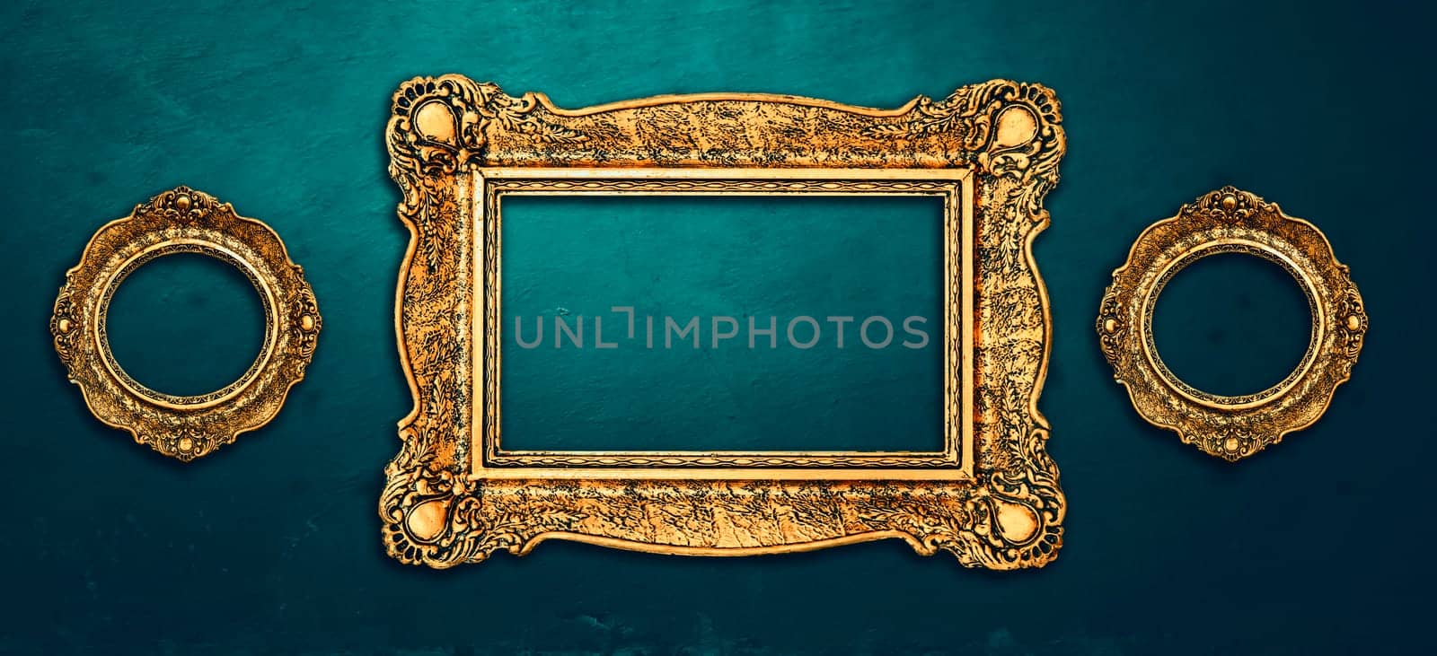 Vintage luxury golden frames set with ornate baroque decoration on rustic textured wall background. Retro fancy picture frames for interior design.