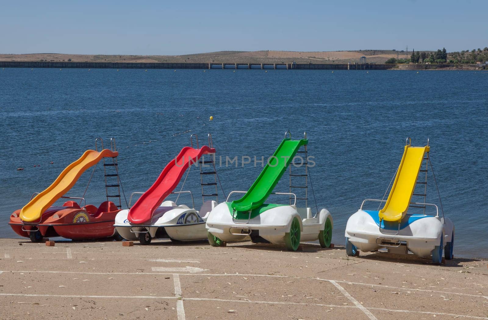 Orellana, Spain - August 4th, 2023: Costa Dulce de Orellana, unique inland beach in Spain awarded with the Blue Flag, Badajoz, Spain. Pedal boats for rent