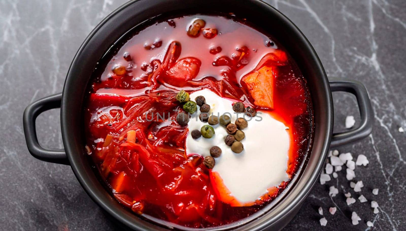 Traditional ukrainian borscht with green onion and sour cream. Delicious beet soup in bowl with rye bread. Top view