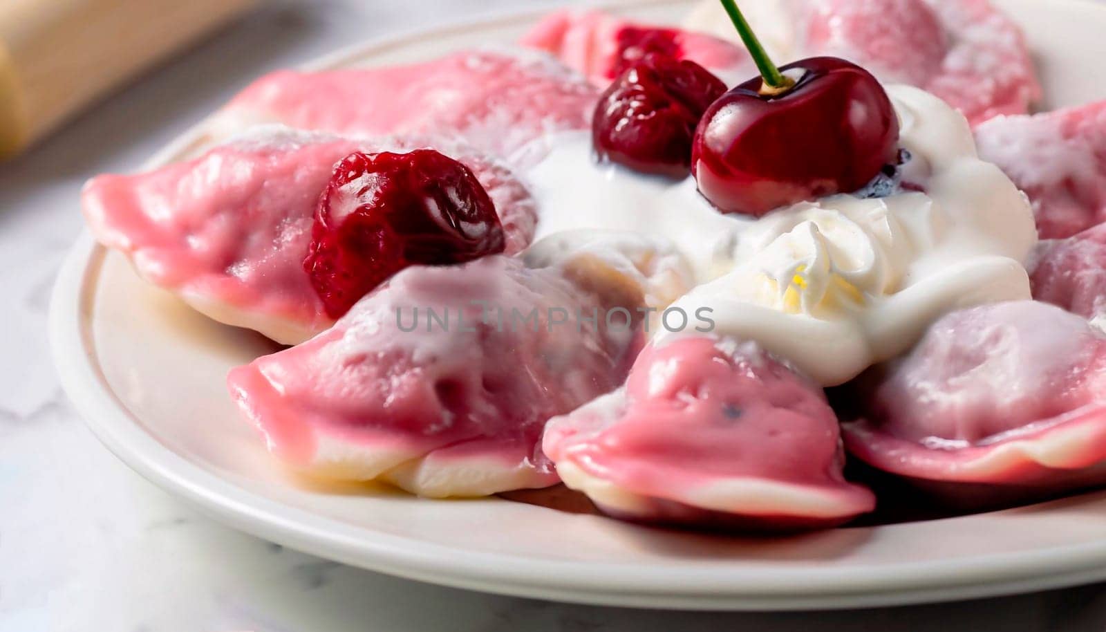 Sweet hearty lunch. Plate of boiled dumplings with cherry filling and sour cream on kitchen table covered with Linen cloth or burlap. Cooking process concept. High angle view, soft focus.