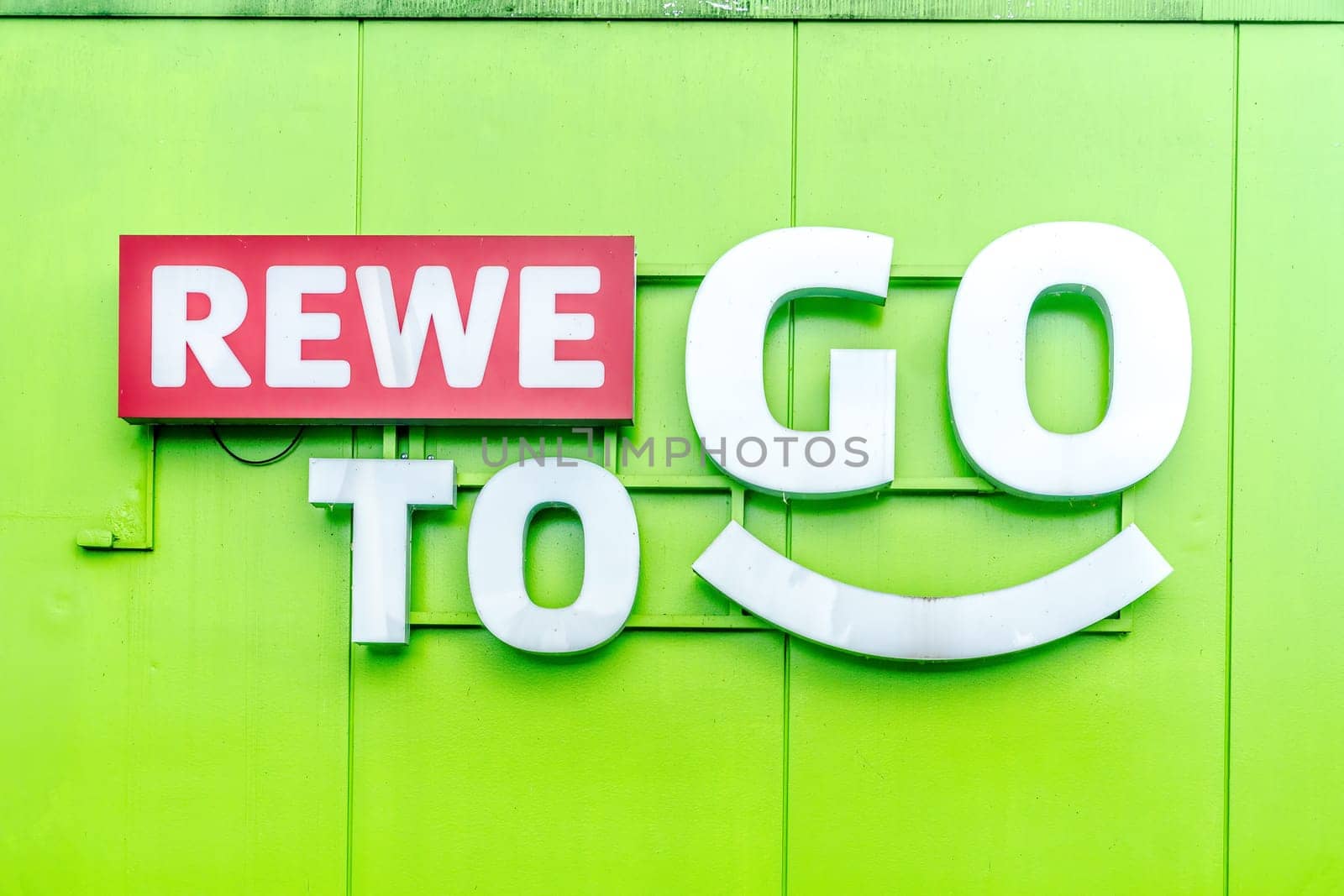 WETTENBERG, HESSE, GERMANY - 07 - 28 - 2023: REWE TO GO on a green house facade. Fast. Fresh. Food.