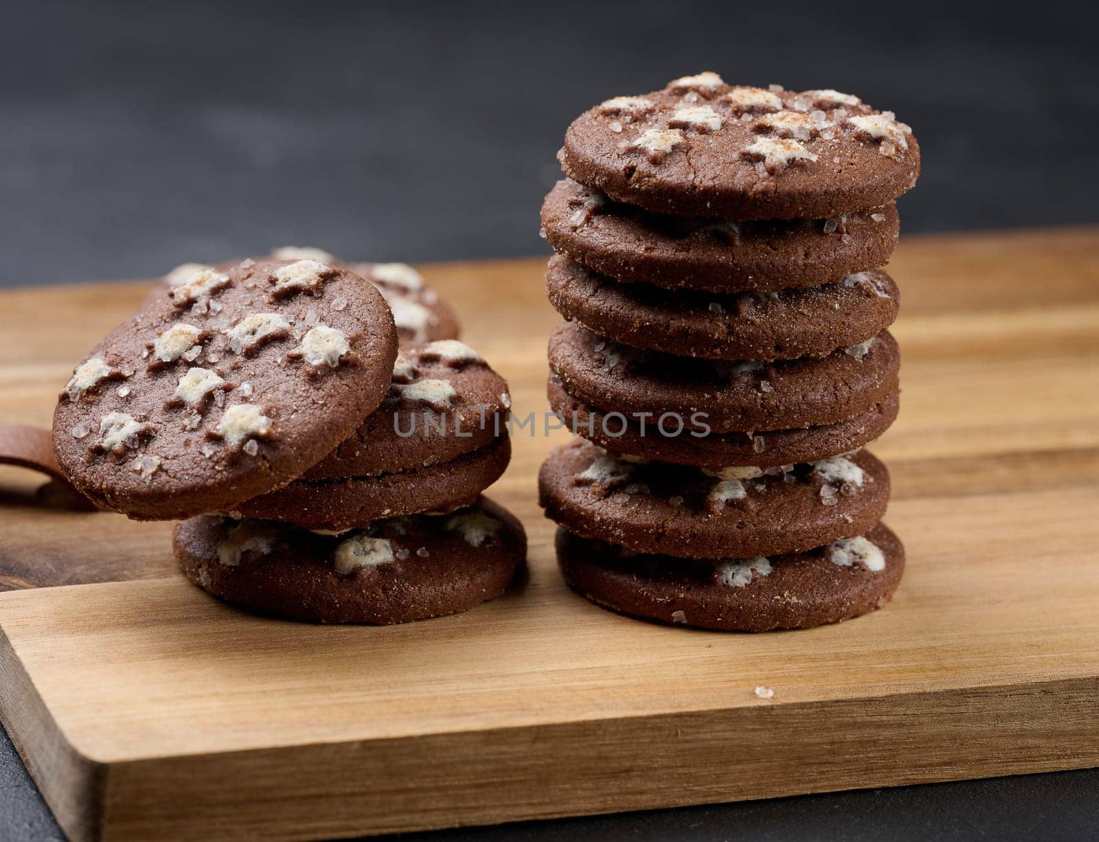 Stack of round chocolate cookies on a black background