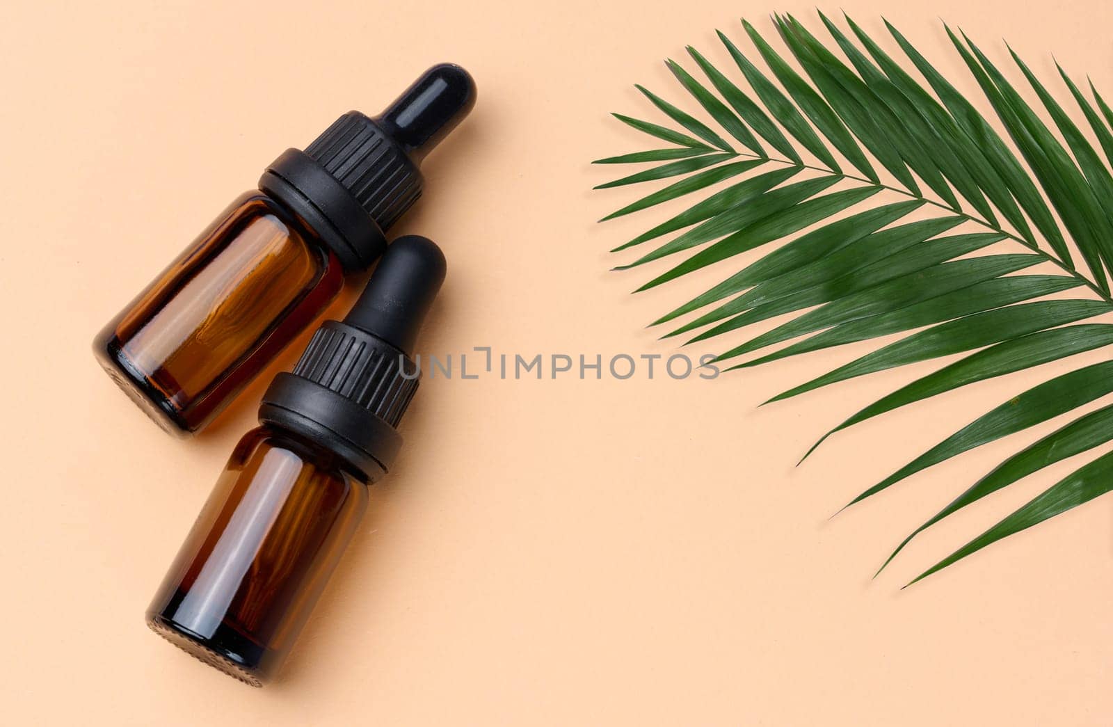 Brown glass bottle with a pipette on a beige background, a container for aromatic oils and cosmetics
