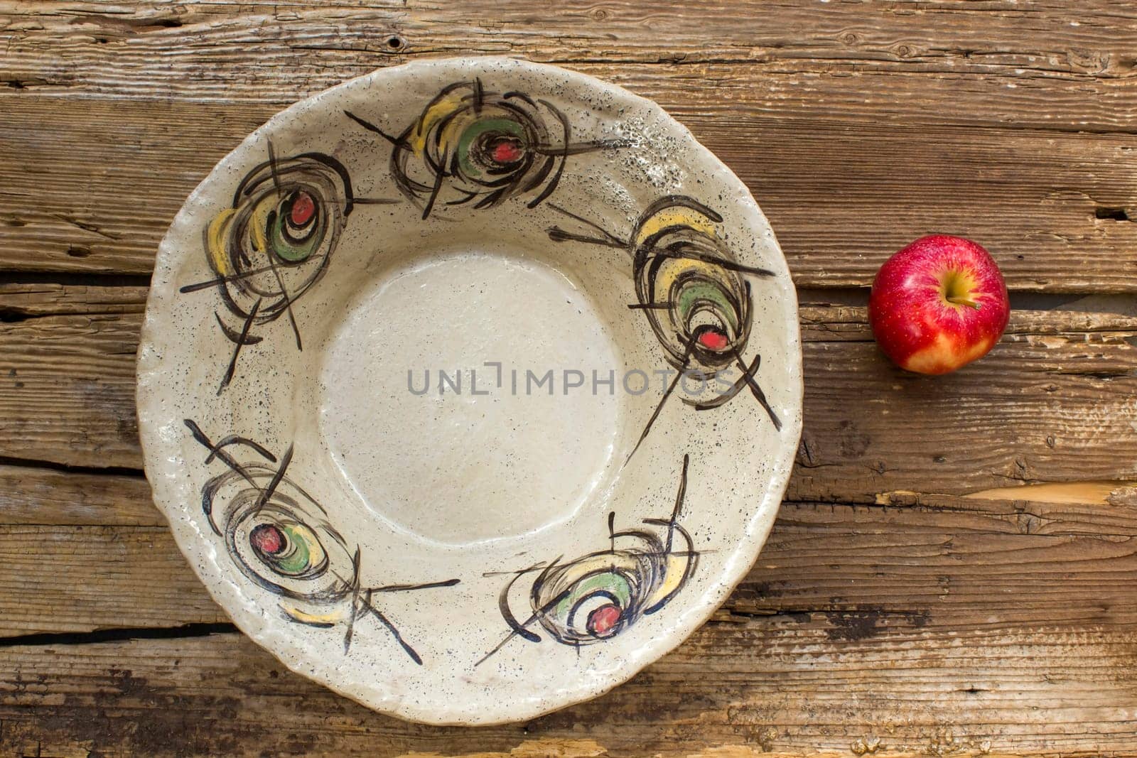 empty bowl and fresh apple on wooden background - handmade pottery