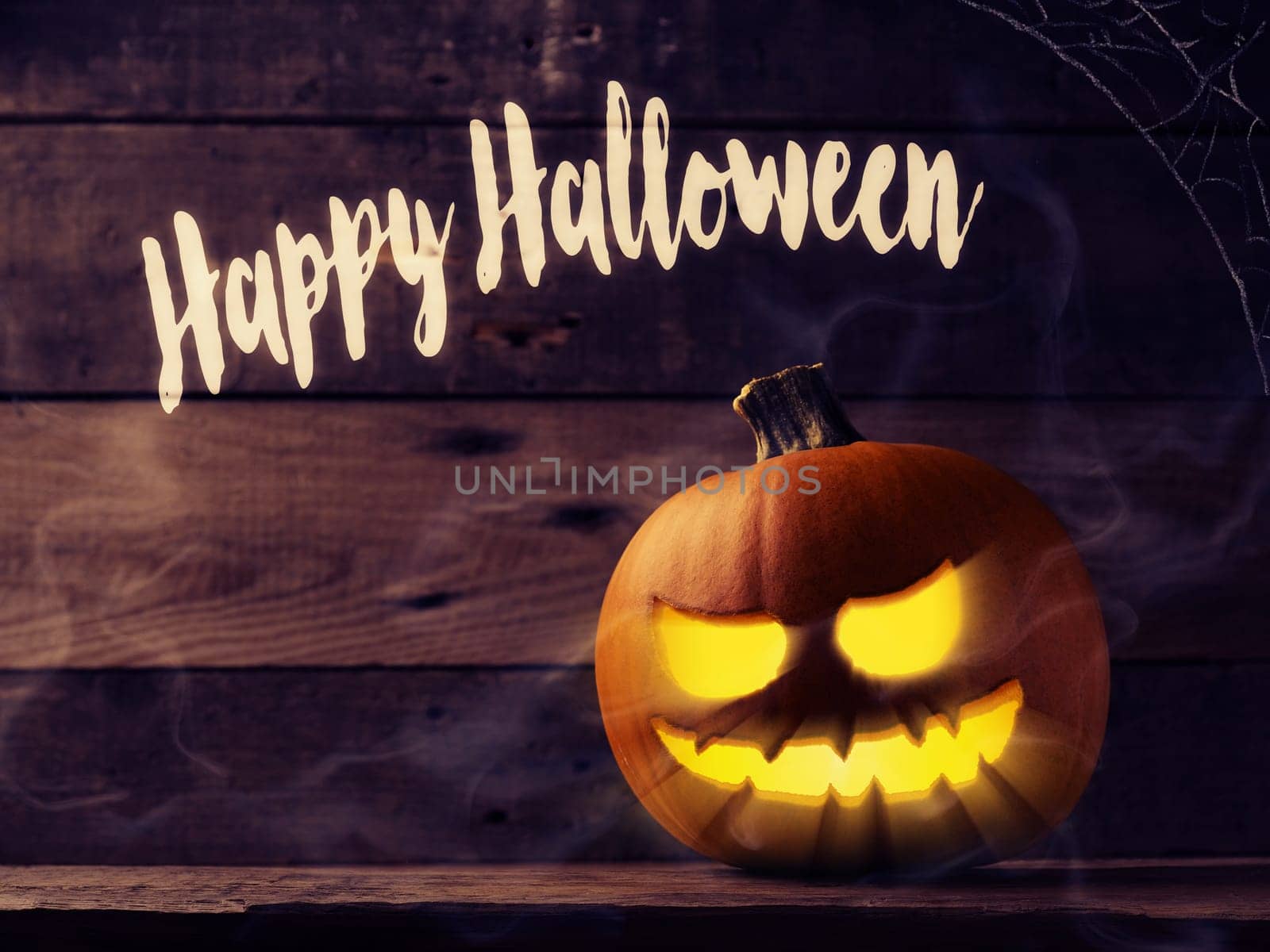 Happy Halloween, carved halloween pumpkin Jack o lantner on a rustic wooden table with mist