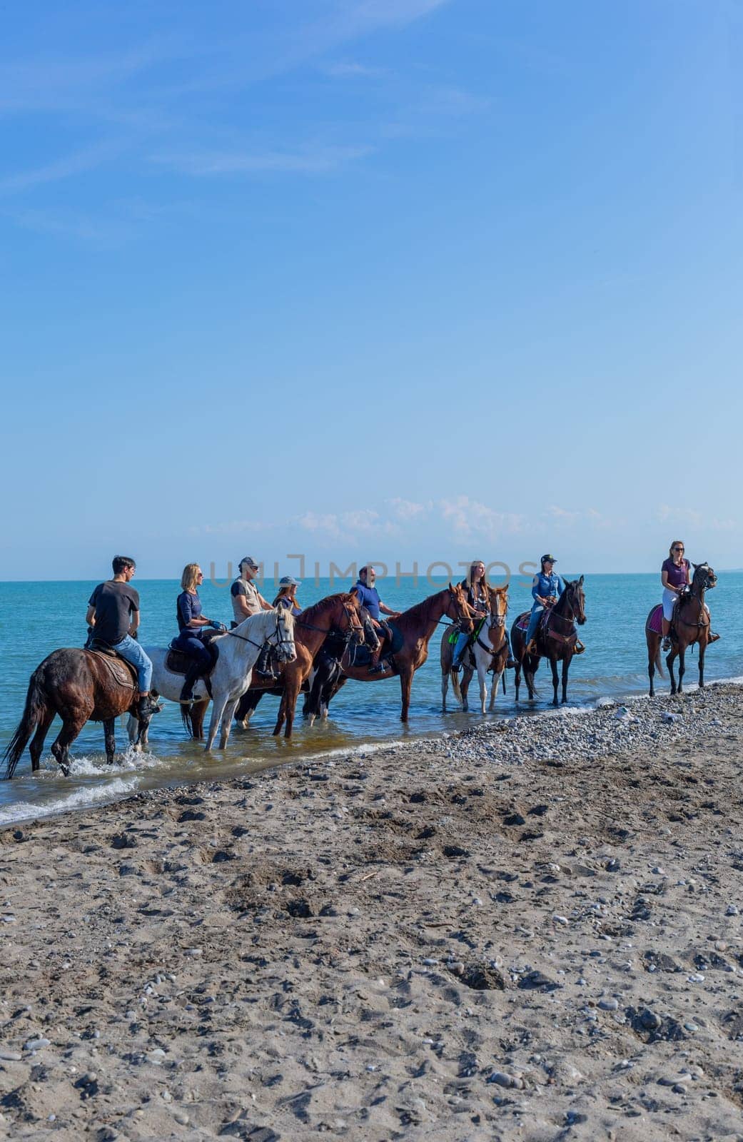 Policoro, Italy - 7 May 2023: People riding horses in a Policoro beach, Basilicata, southern Italy.