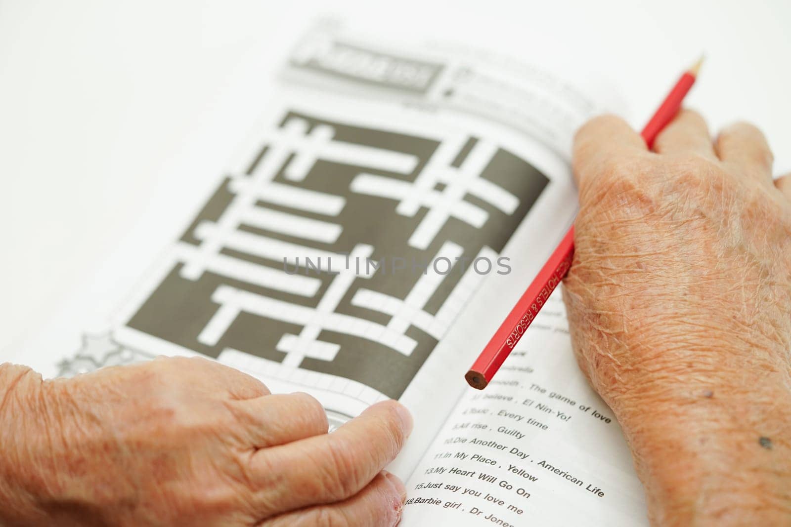 Asian elderly woman playing sudoku puzzle game for treatment dementia prevention and Alzheimer disease.