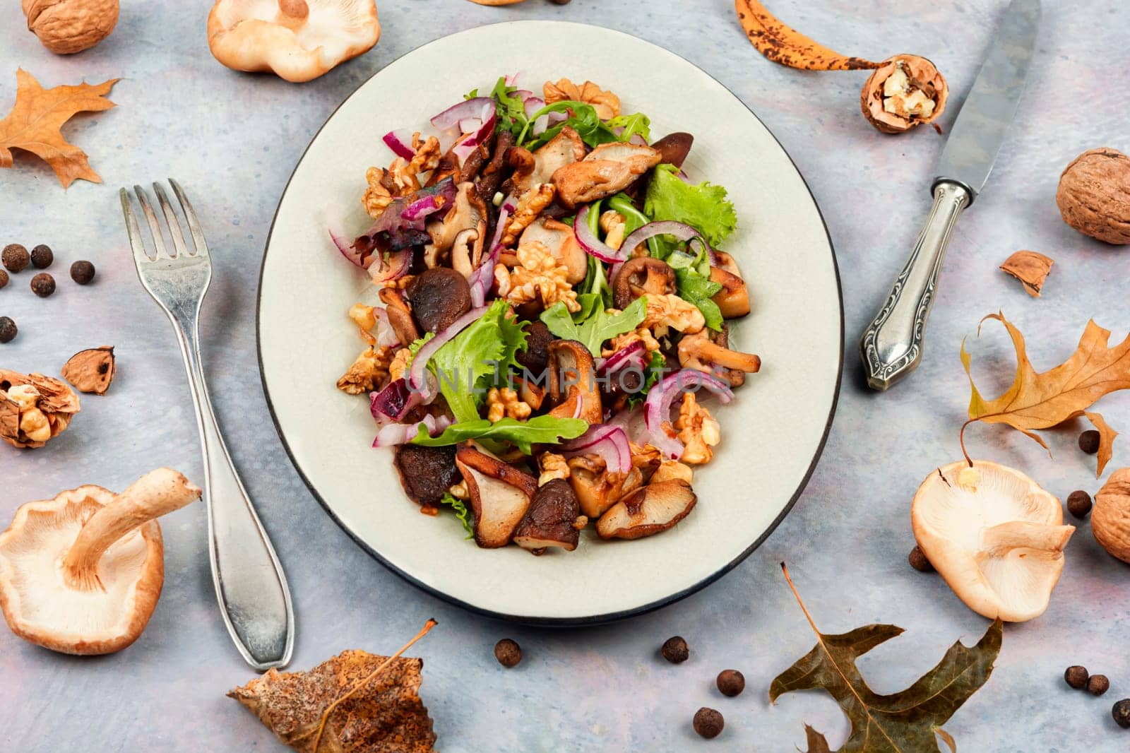 Dietetic warm salad with grilled forest mushrooms, onions, herbs and walnuts.