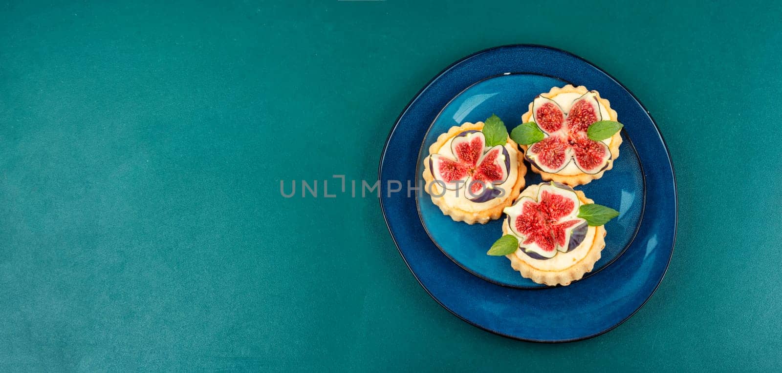 Appetizing tartlet dessert with whipped cream and figs. Delicious fig pie.
