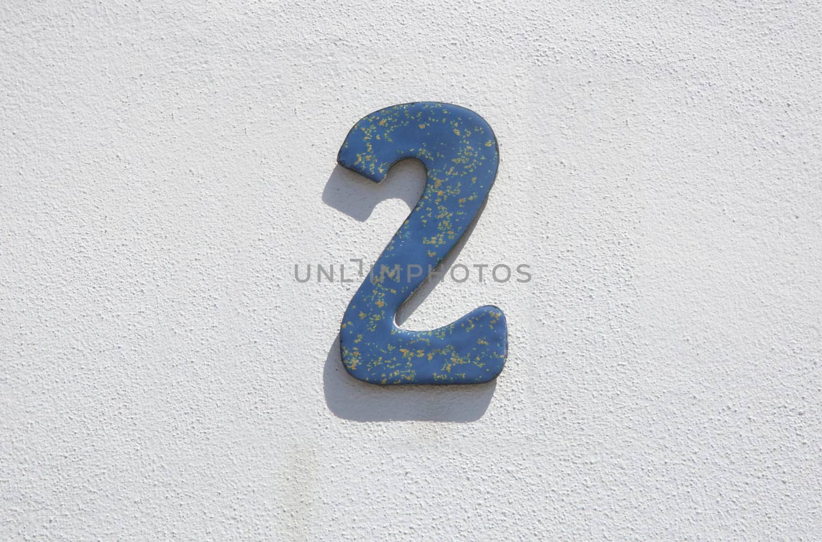 House number 2. Painted iron over whitewashed wall. Houses with personality concept