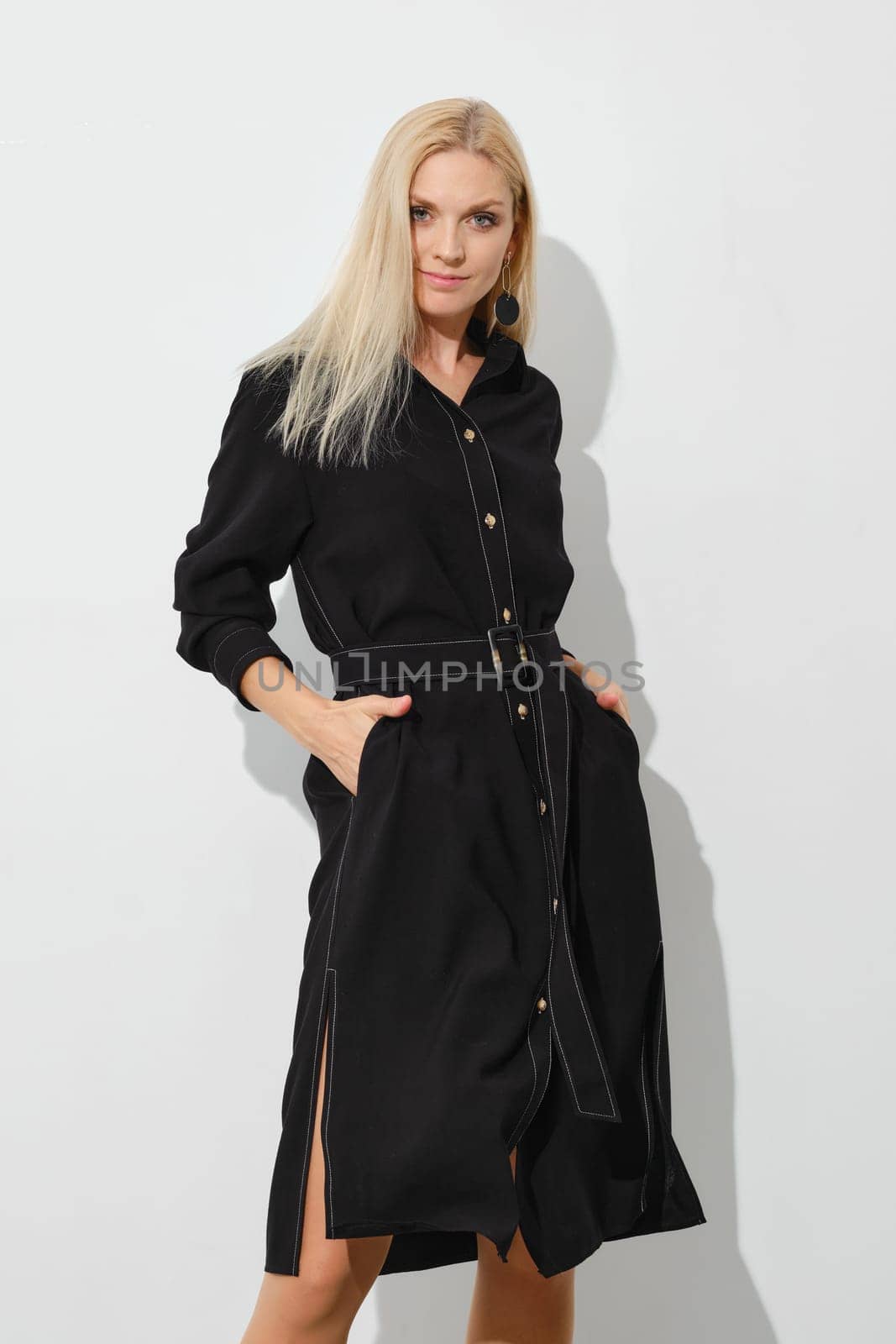 Cute woman in button down dress with hands in pockets