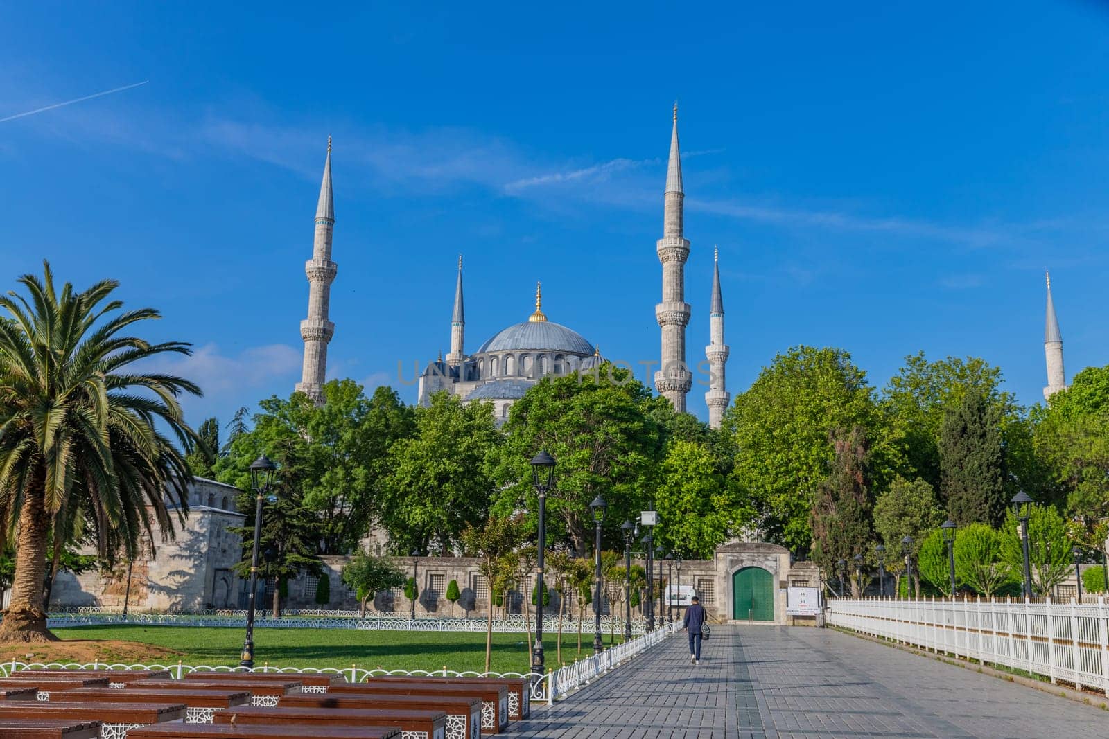 Istanbul, Turkey - June 05, 2023: Man Walking in the Park with Blue Mosque in the Background