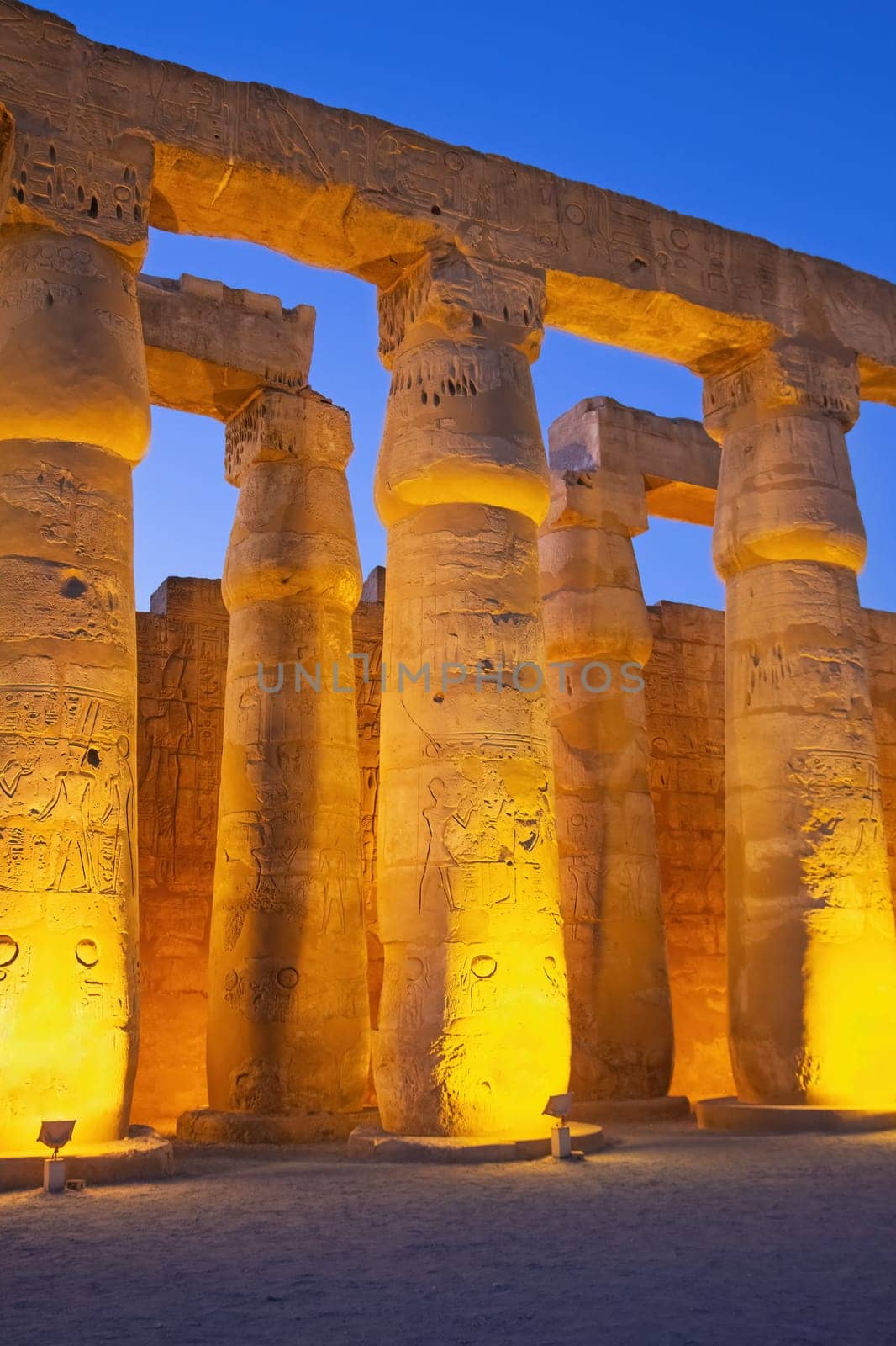 Illuminated columns of Karnak temple.. Night photo. Luxor, Egypt. Vertically.