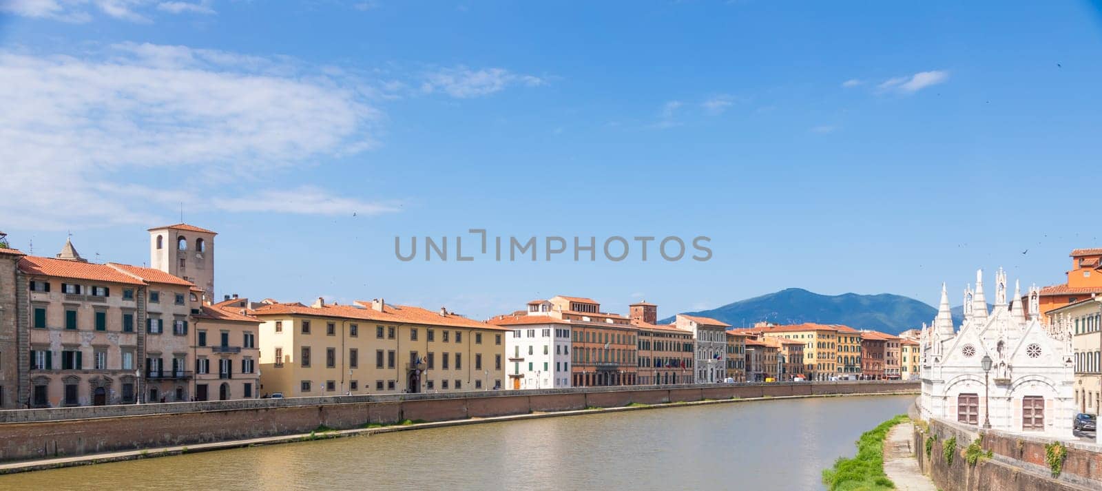 Pisa, Italy - 29 June 2023: colourful buildings on Arno river. Urban skyline, travel destination.
