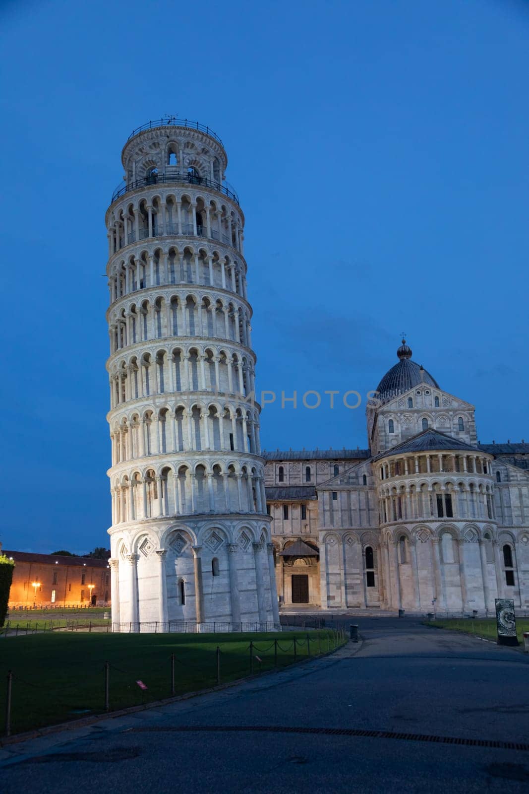 Pisa, Italy - 01 July 2023: leaning tower and cathedral panorama by night, blue sky
